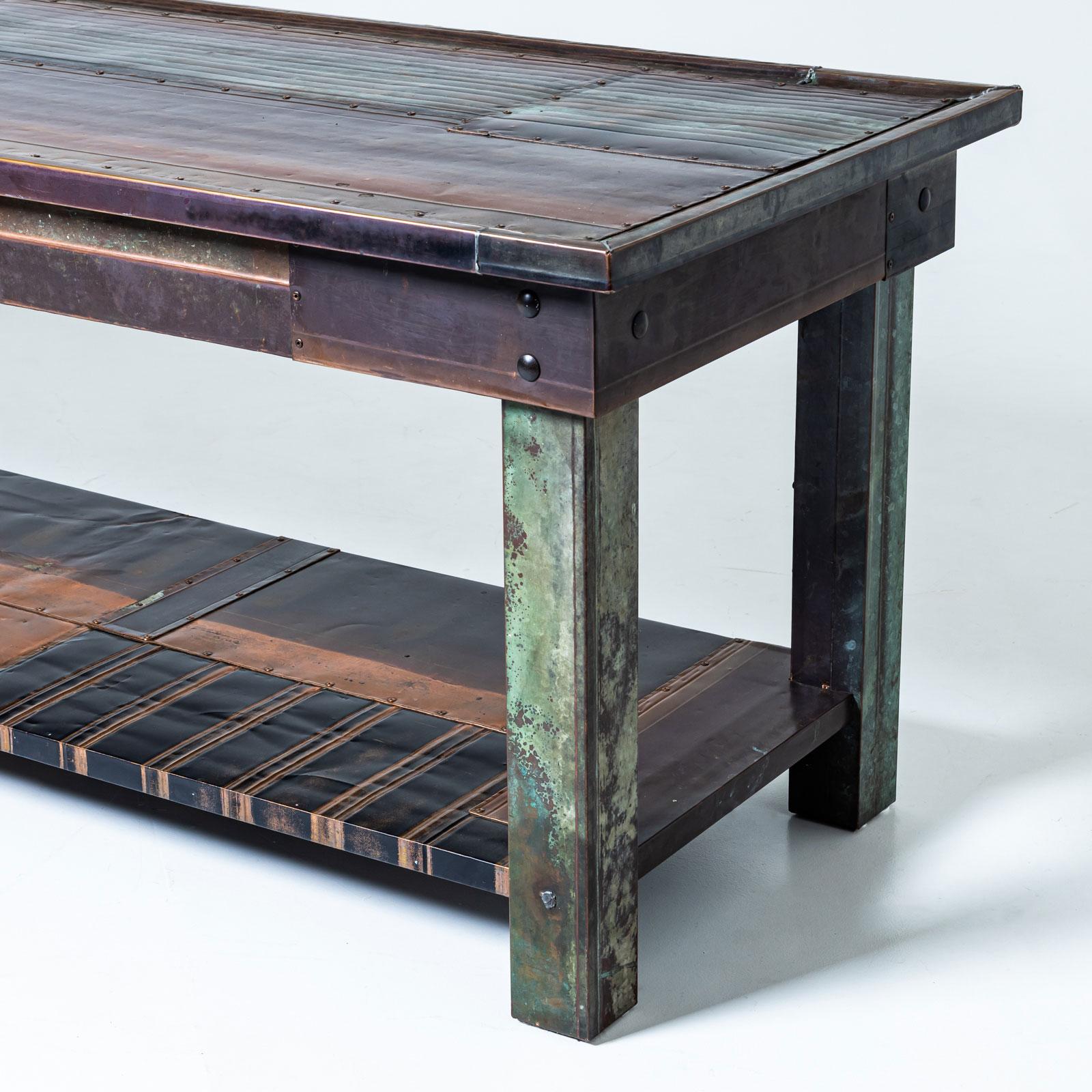 Impressionnante table console de Vincenzo de Cotiis, fabriquée à partir de plaques de métal avec une finition bleutée distinctive. Le design épuré et géométrique est accentué par des pieds rectangulaires et droits et une étagère intégrée entre eux.
