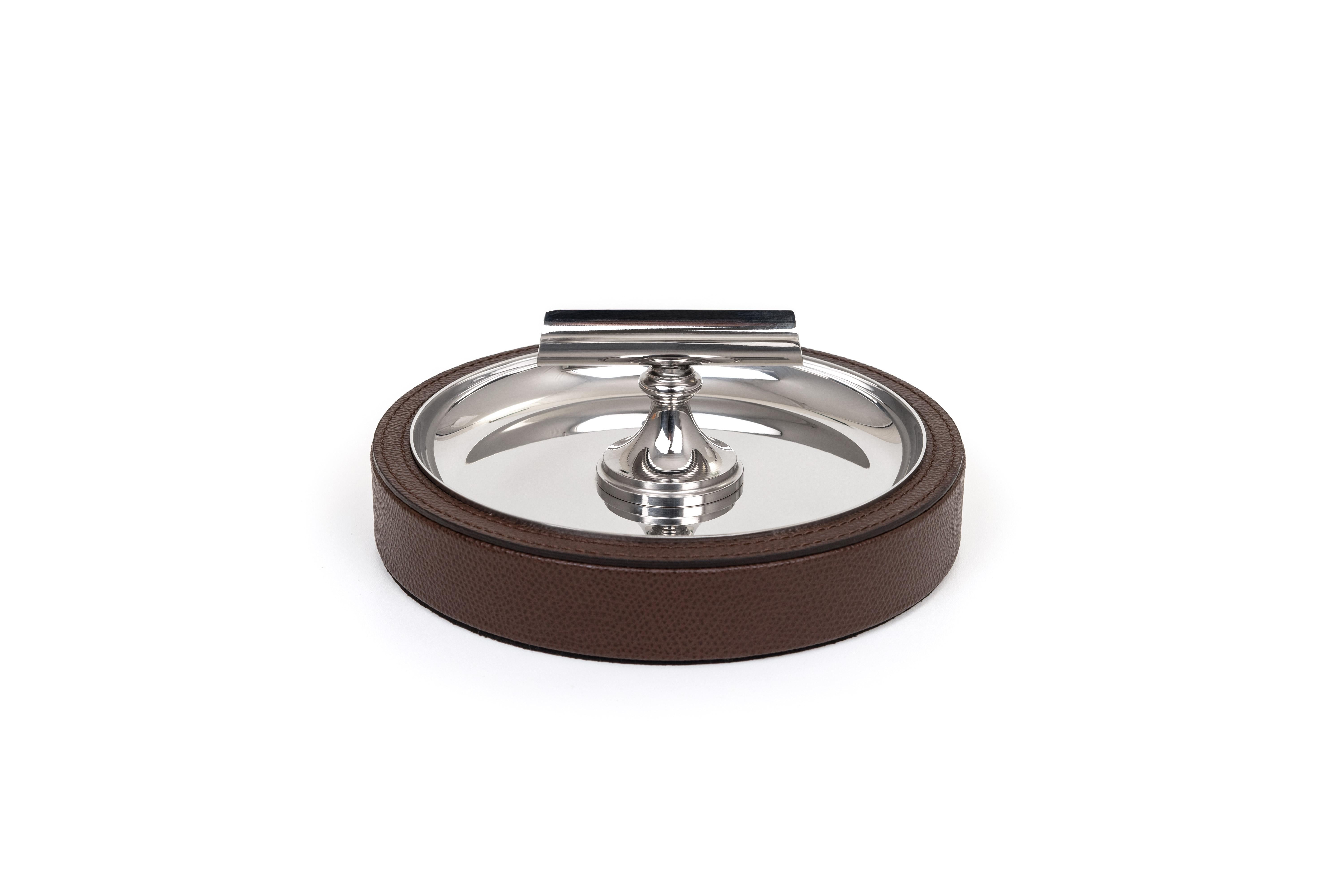 For poker nights. A Compact design with a single cigar rest, this piece serves both as an ashtray and support for the cigar. It is made out of polished steel with a wooden base trimmed with a soft calf leather.

Available with different kinds of