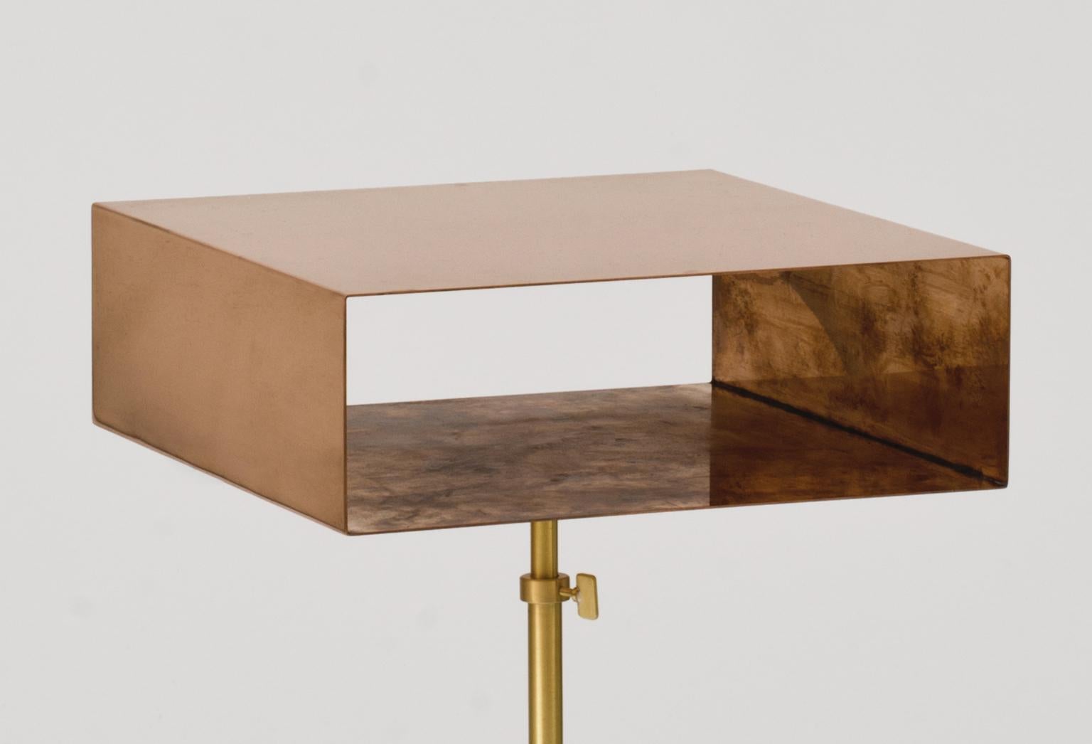 These brass and copper side table are inspired to the adjustable bases of the canterburies at La Scala in Milan. The inner part of the brass top oxidizes with the passing of time, which will confer a retro allure to this unique piece. 

Each piece