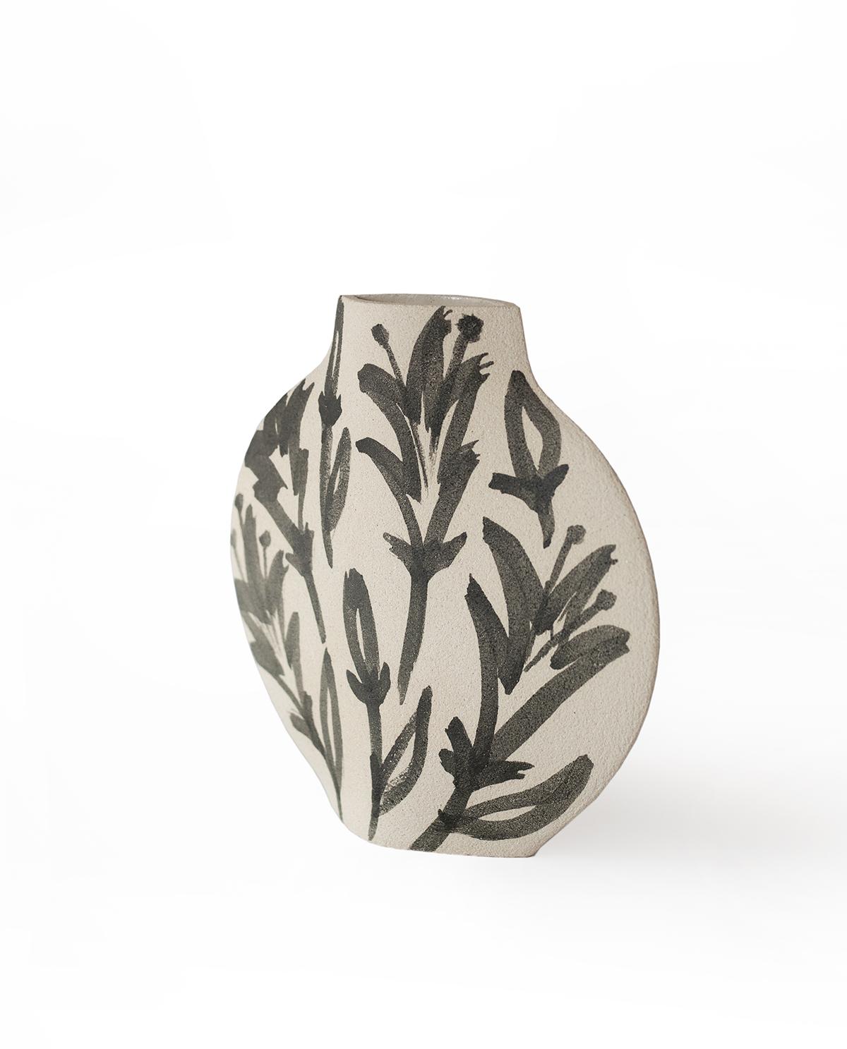 'Lilies’ handmade white ceramic vase.

This vase is part of a new series inspired by flowers (and more generally organic elements). Here is our Lune [M] model with motifs based on lily flowers. They are hand painted on the vase before its first