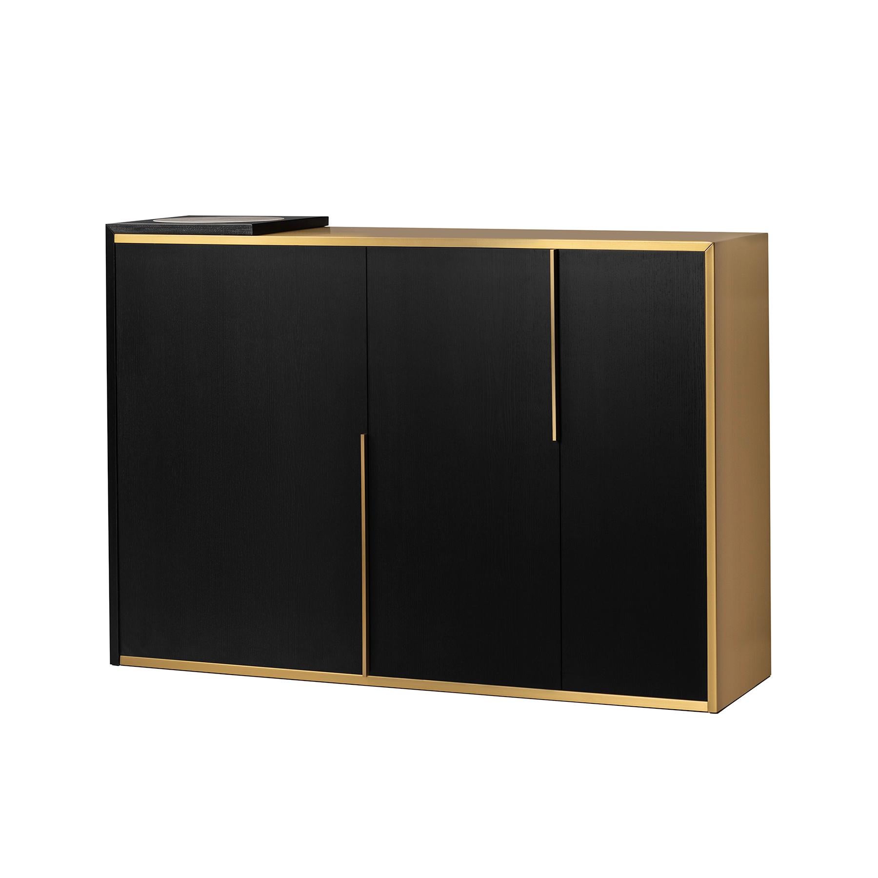 Proportion and compositional elegance for a timeless piece of furniture.
Satin-finish brass embraces the deep black of the ash wood like a line of light, while a disc of Calacatta marble shines ethereally on the top.
Each element is in harmonious