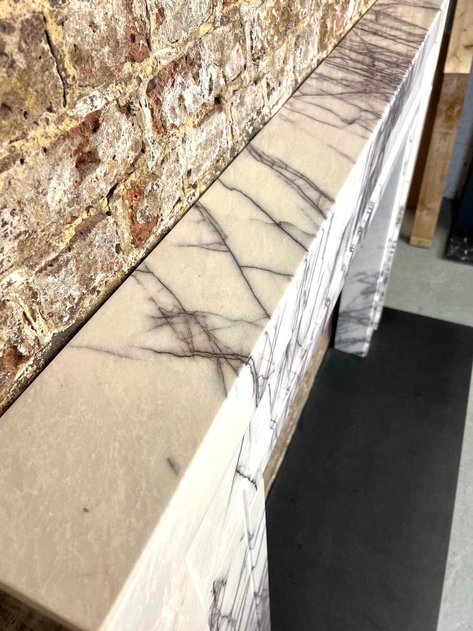 Cheminée en marbre du 21e siècle.
Cette cheminée contemporaine de fabrication récente s'inspire légèrement d'un design Art déco.
Il a été sculpté à la main dans un marbre Breccia Lilac Viola.
Design/One à la fois simple et élégant, avec des panneaux