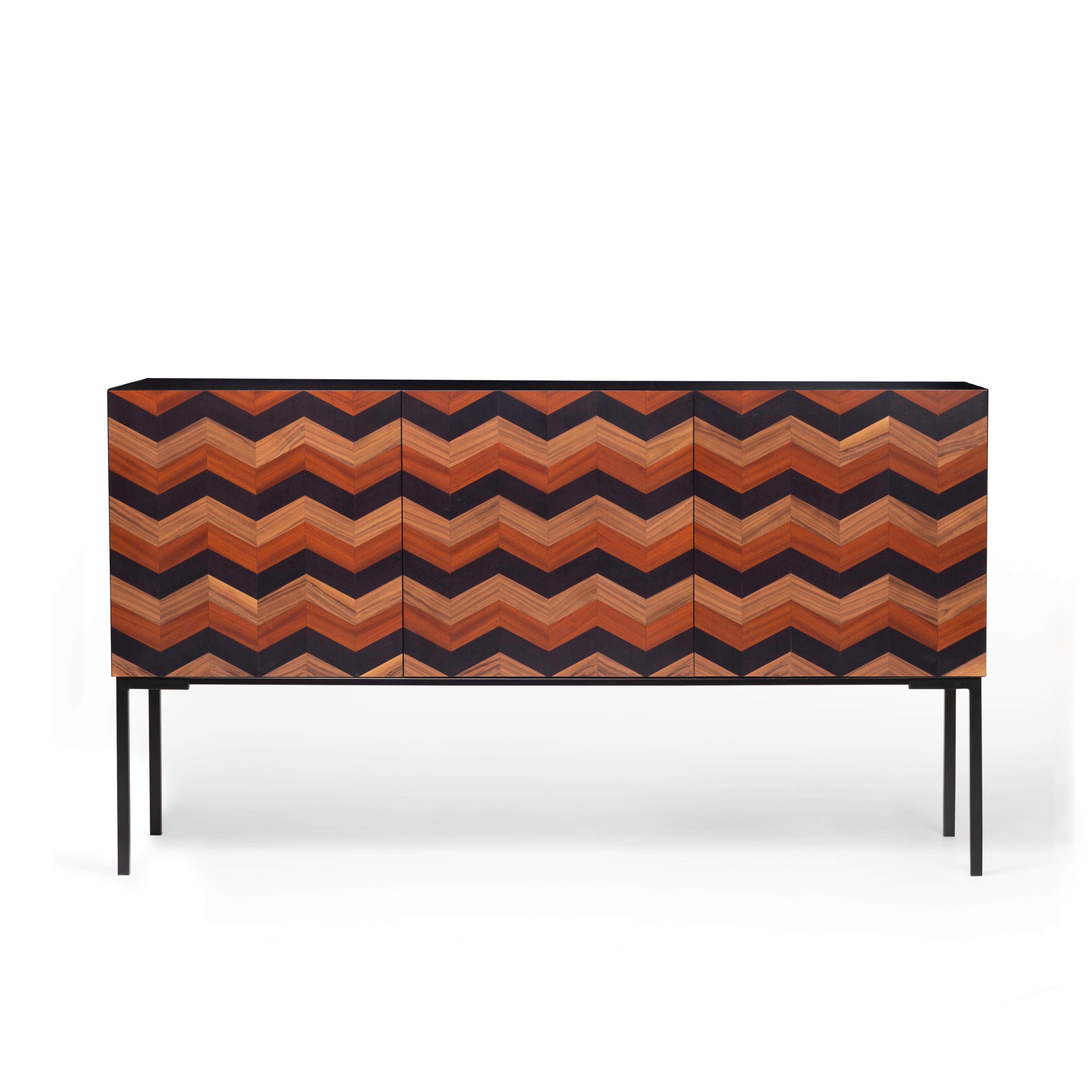 The Marea sideboard is dressed in the warm, deep colors of a sunset by the sea, an inlay that embraces the surfaces like waves shining in the last rays of the sun. Because no home should live without the sea... 
Wooden sideboard, 21st Century