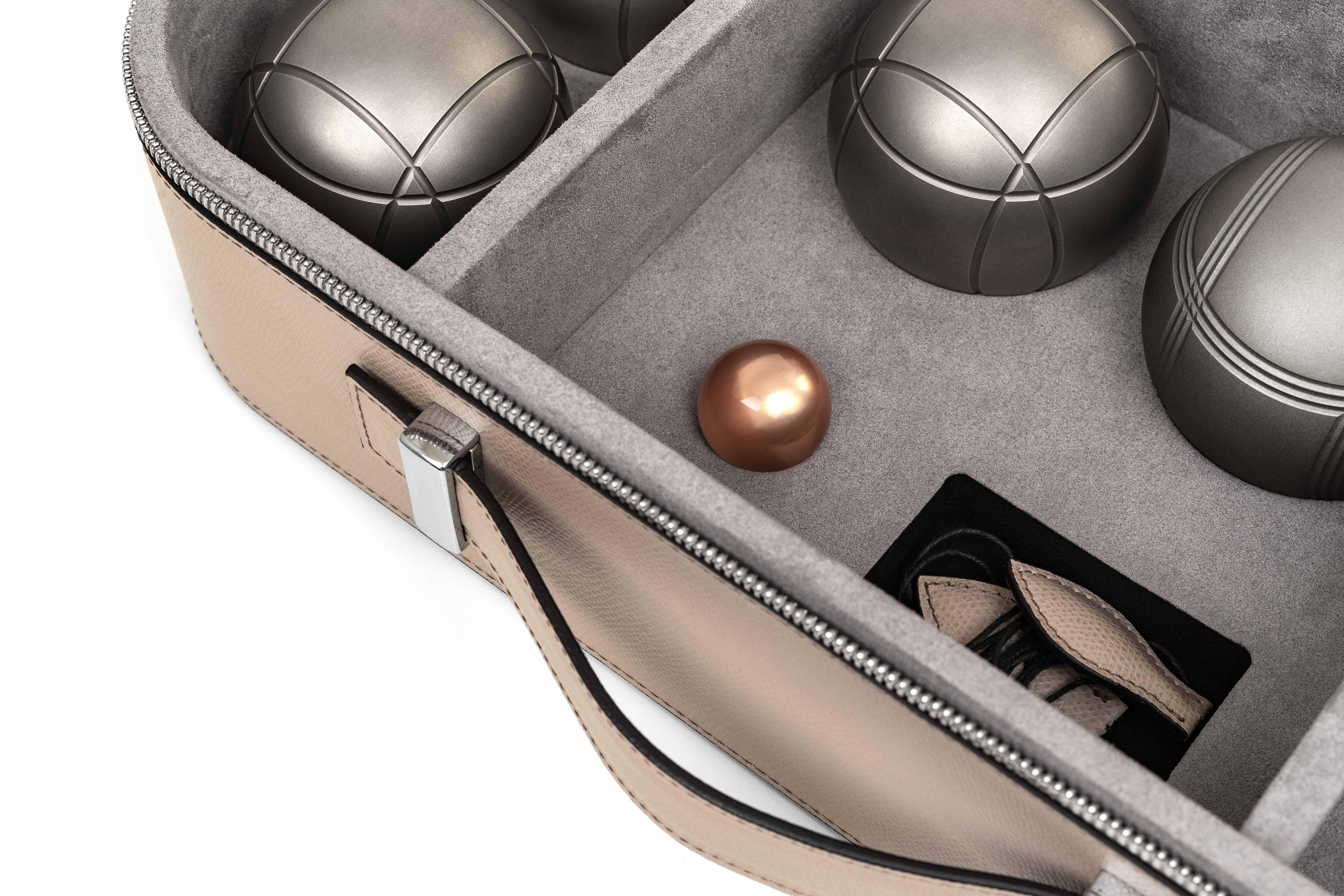 A complete game set of 6 metal balls with one jack and a leather measuring rope.

Our portable Pétanque game set comes with its own sleek storage box, completely covered with genuine grained leather. Ideal for outdoor entertaining or as a perfect