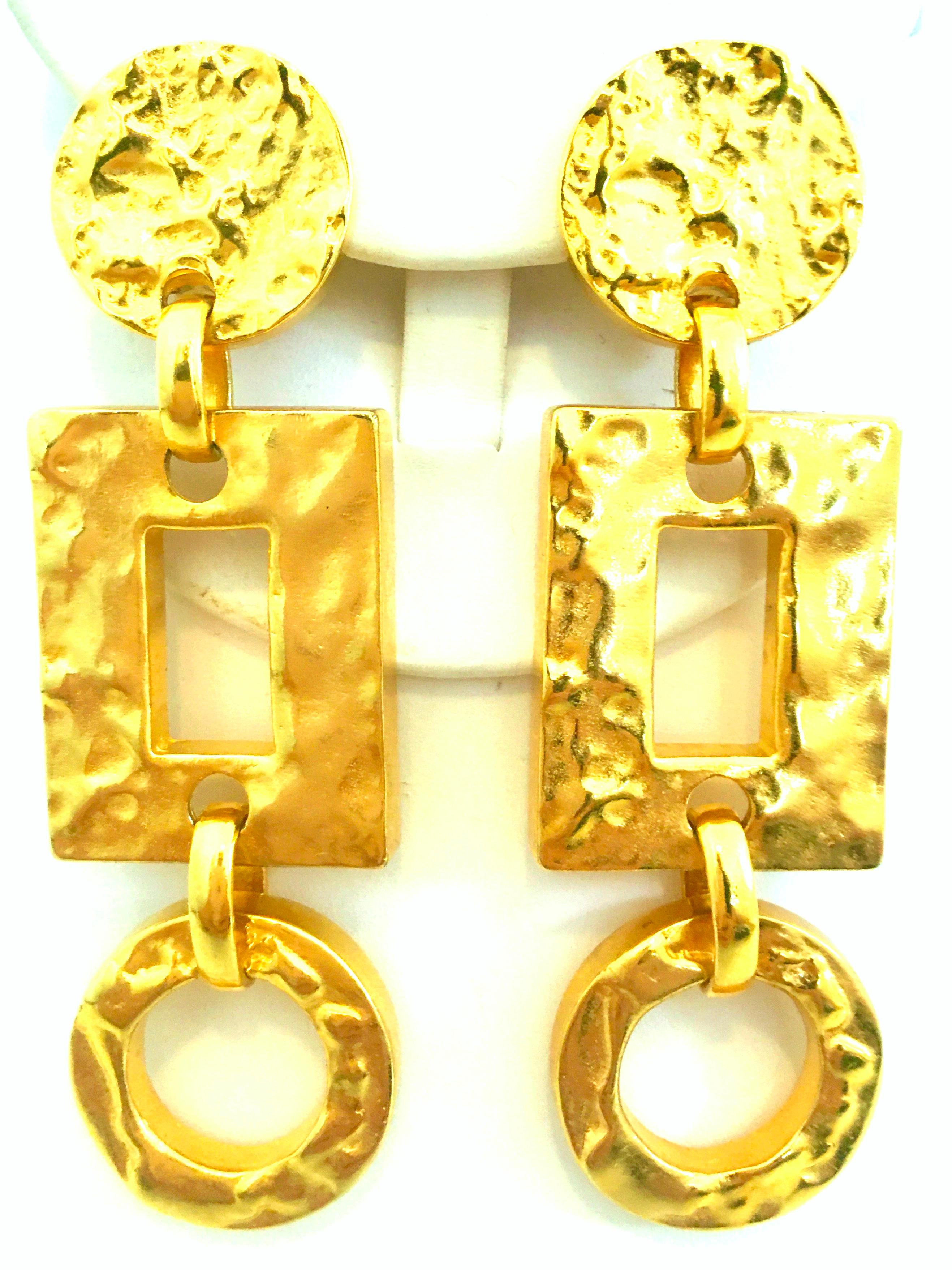 21st Century Michael Kors gold plated monumental pair of Modernist dangle earrings. Features a hammered finish with geometric shapes. Procured from the Michael Kors Boutique-Worth Av. Palm Beach island, these substantial clip style earrings are like