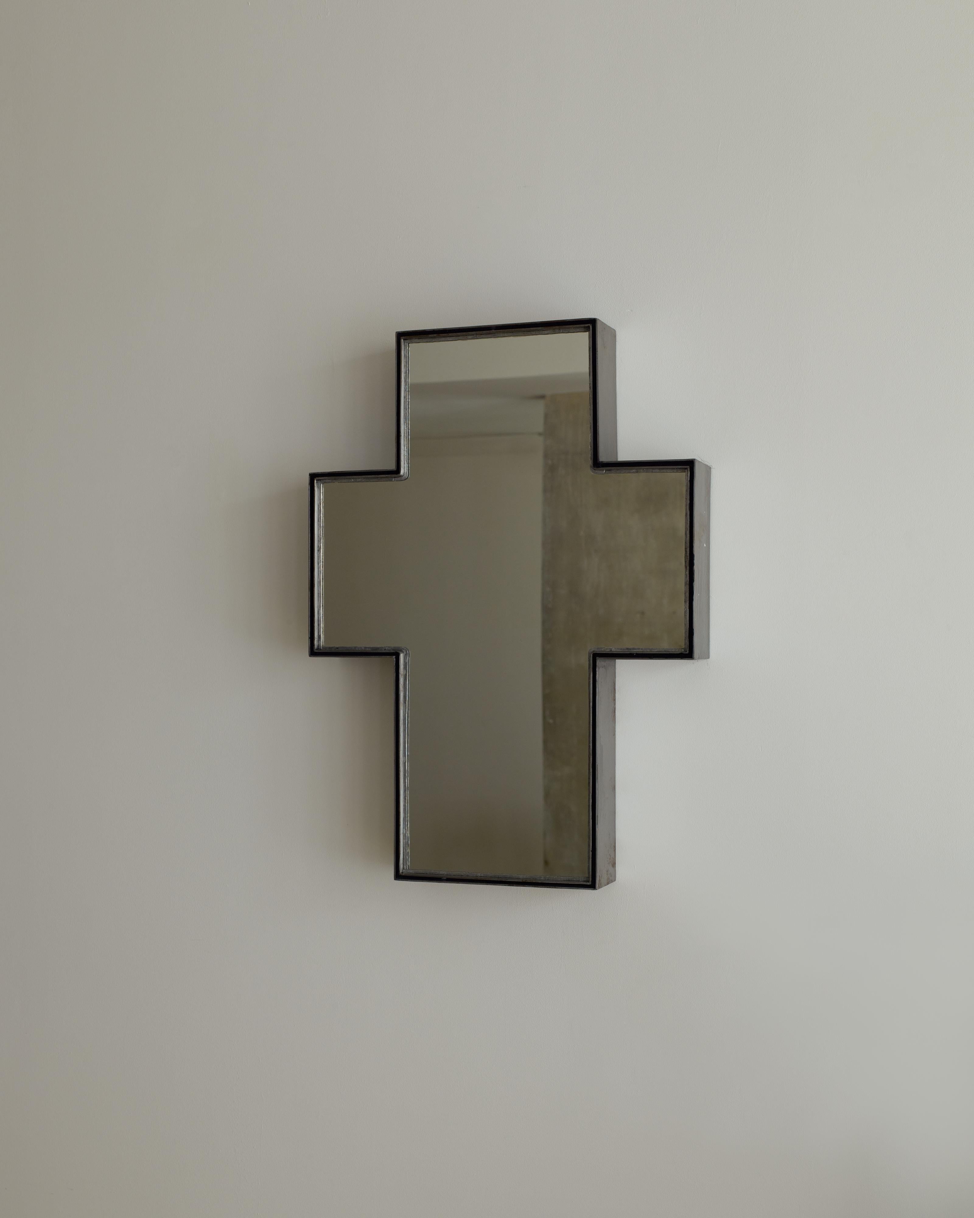 'Talisman Mirror No. 3' by Rooms Studio is an iron-framed wall mirror in the form of a Latin cross (Crux Immissa). Dubbed 