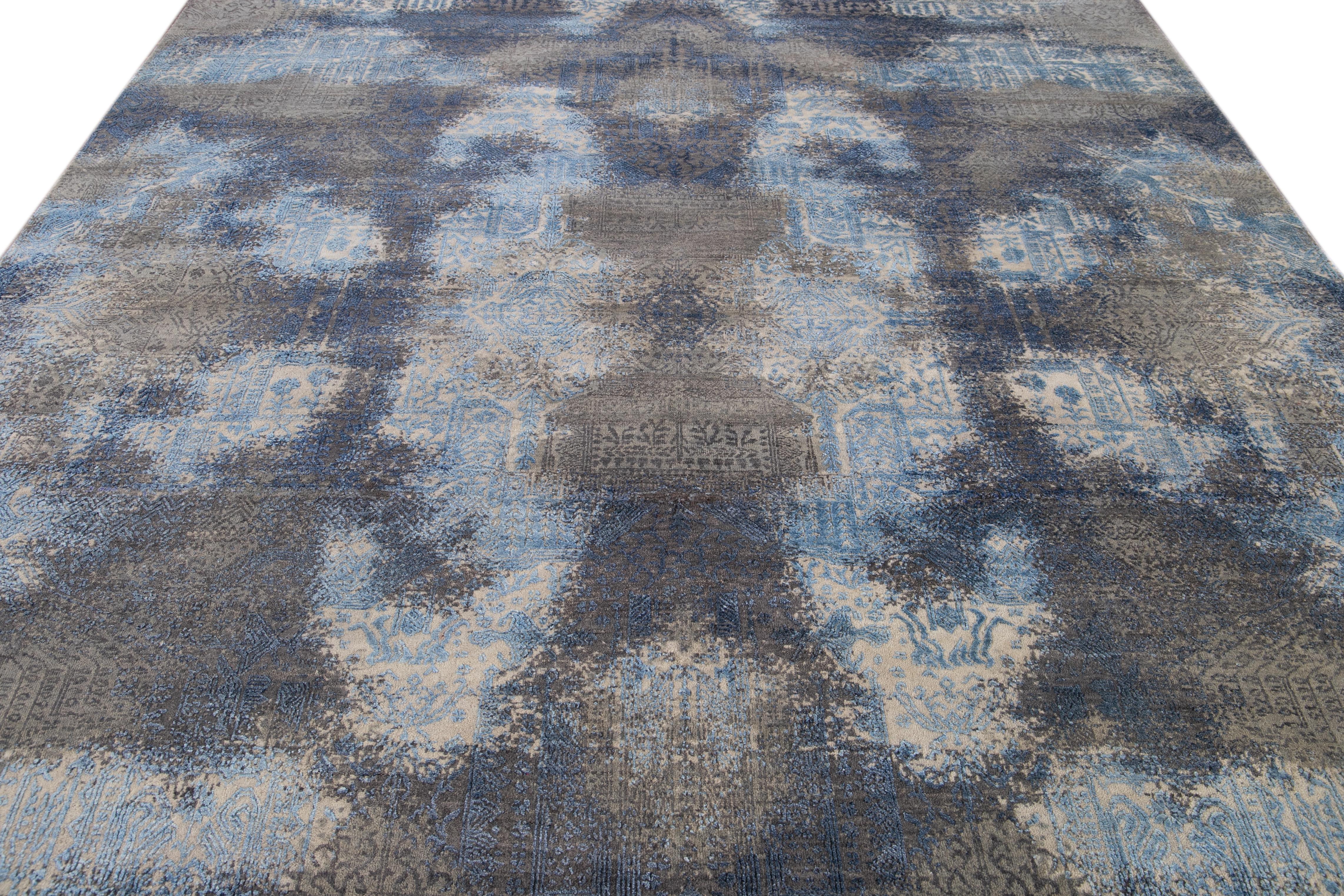 Beautiful modern hand knotted wool rug. This rug has a blue field with abstract accents of gray and light shades of blue all-over. 

This rug measures 10' 1