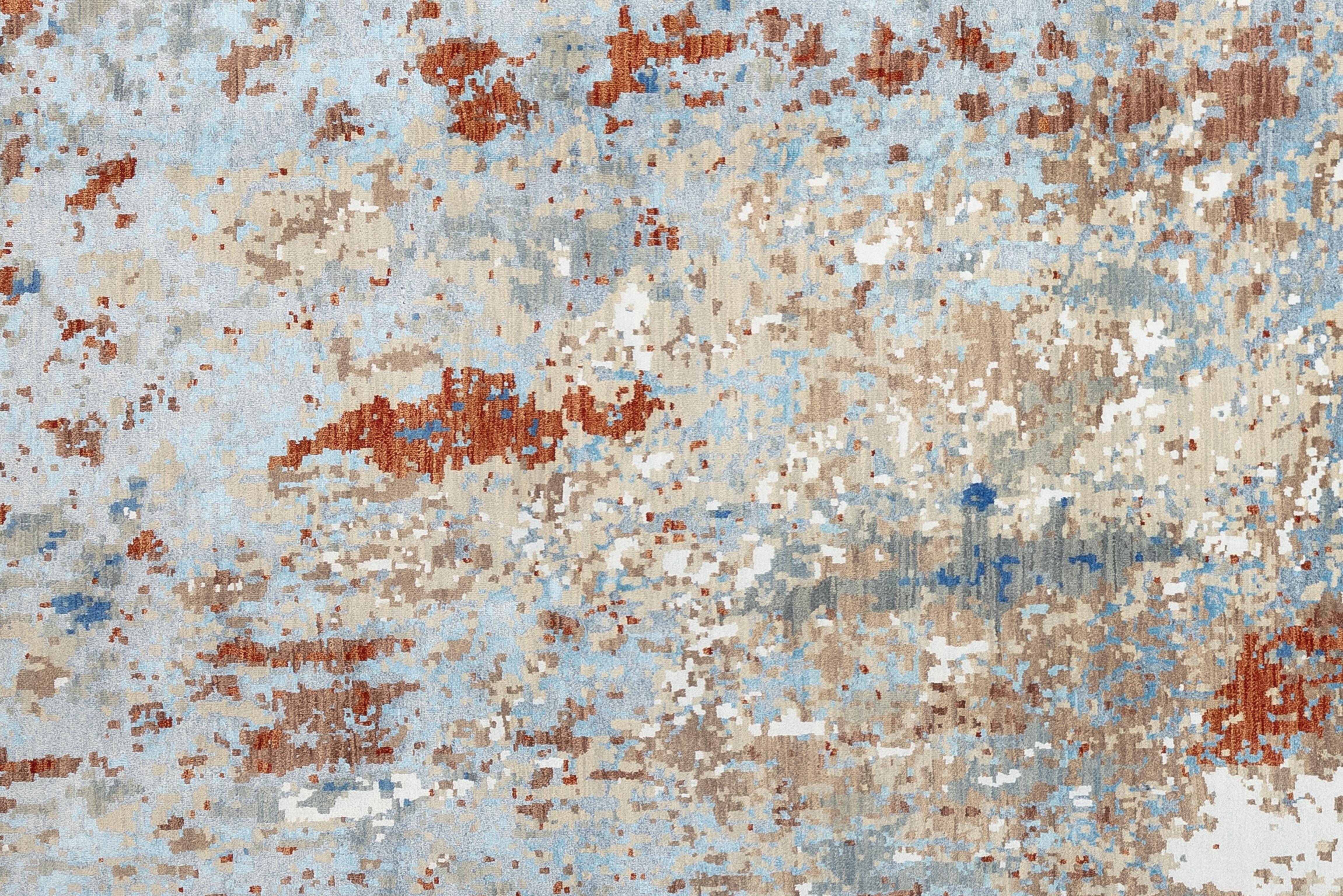 Dieser brillante und kühne zeitgenössische Teppich weist eine wahrhaft atemberaubende Palette von Erdtönen auf. Von Blautönen bis hin zu Kastanien- und Beigetönen,  dieses Stück wird Sie sicher begeistern. Wunderschön handgewebt in Indien aus 100%
