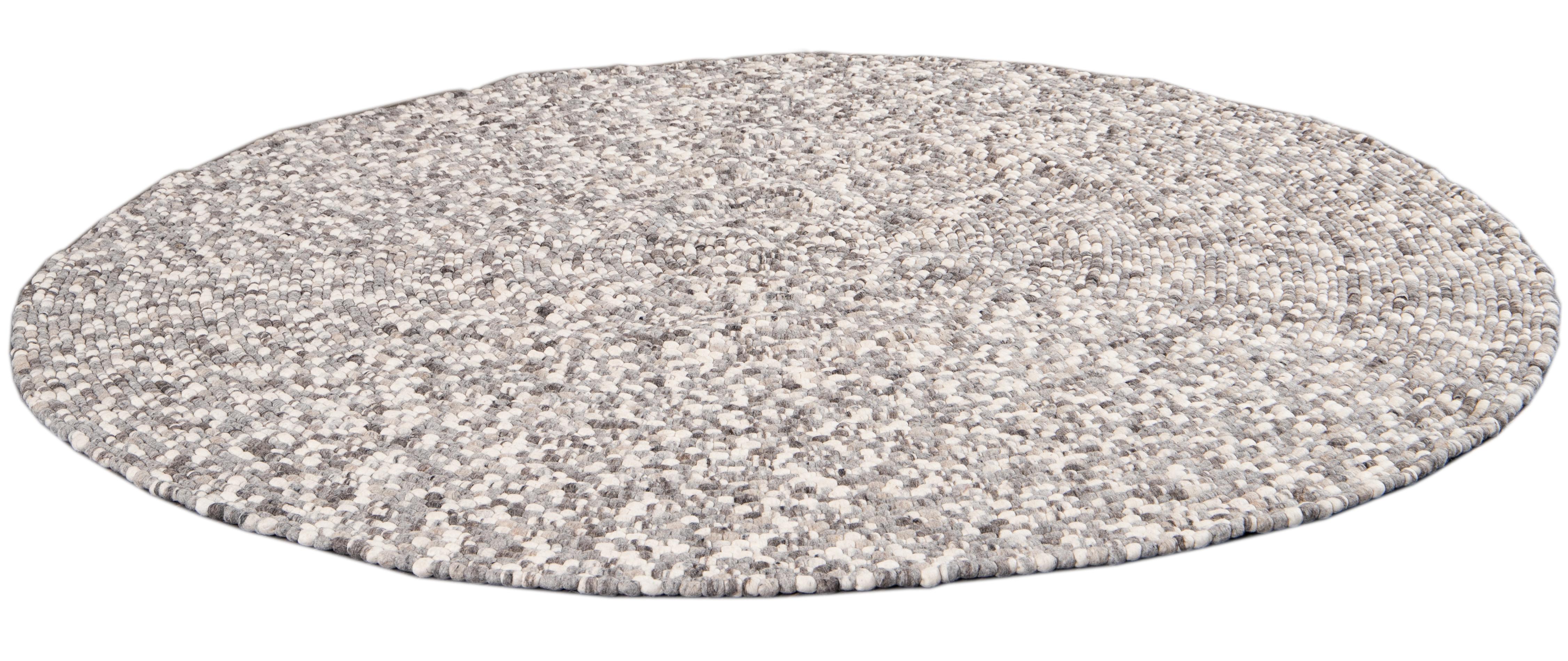 Beautiful contemporary Round Textured rug, hand knotted wool with an ivory field, tan and gray accents.

This rug measures 8' 0