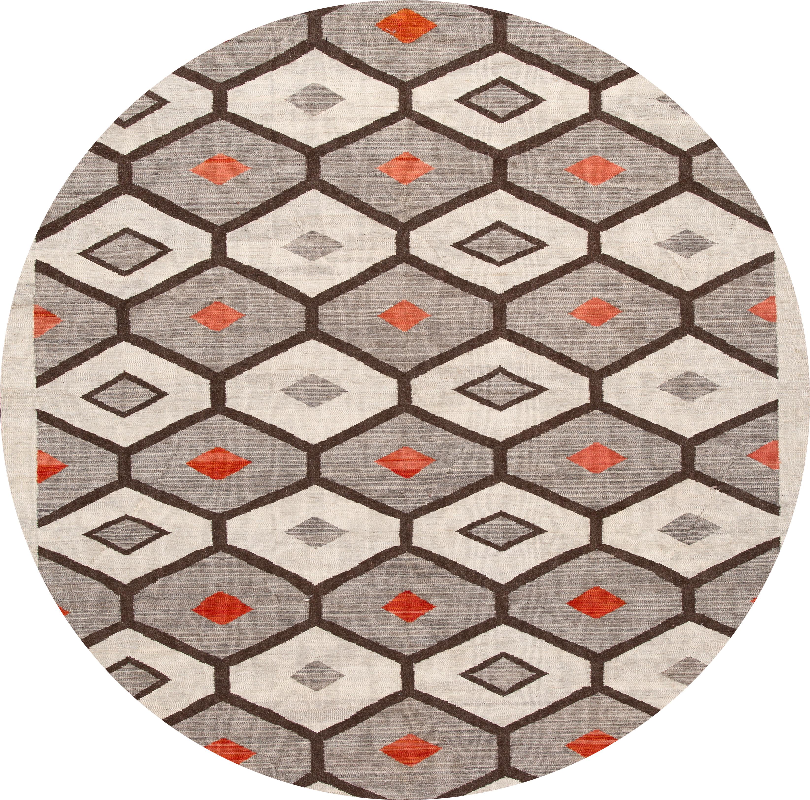 Magnifique tapis contemporain à tissage plat de style Navajo, un tapis en laine tissé à la main avec un champ gris, des accents ivoires et rouges dans un design géométrique all-over.

Ce tapis mesure 9' 9