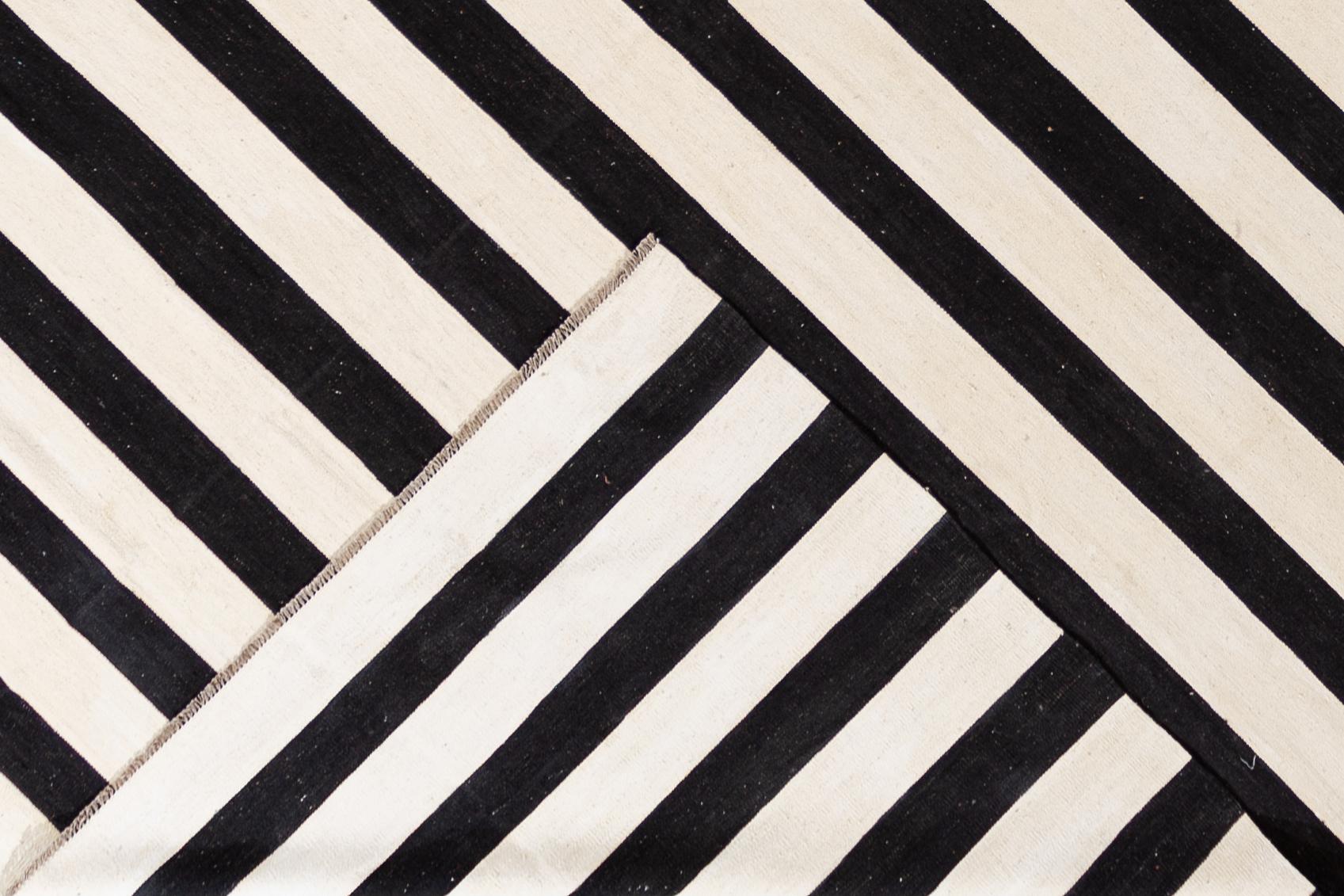 Beautiful 21st century contemporary Kilim rug, handwoven wool in an all-over black and white striped design.

This rug measures 12' 2