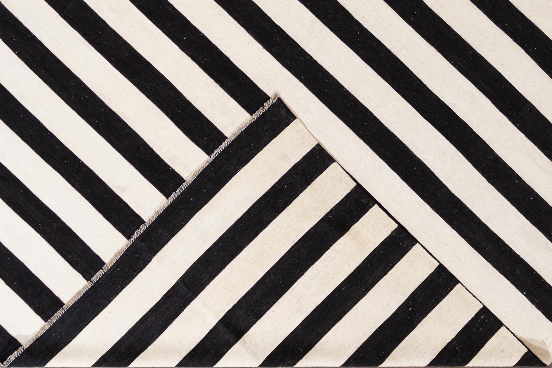 Beautiful 21st century contemporary Kilim rug, handwoven wool in an all-over black and white striped design.

This rug measures 12' 1