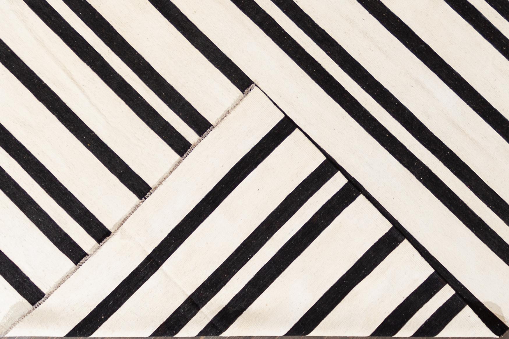 Beautiful 21st century contemporary Kilim rug, handwoven wool in an allover black and white striped design.

This rug measures 11' 8