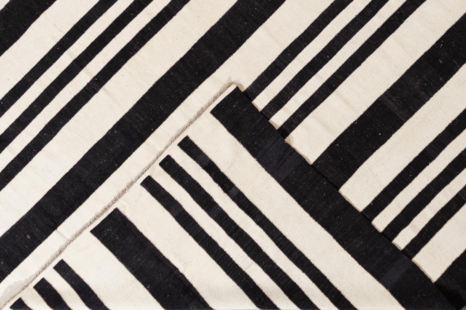 Beautiful 21st century contemporary Kilim rug, handwoven wool in an all-over black and white striped design.

This rug measures 12' 3