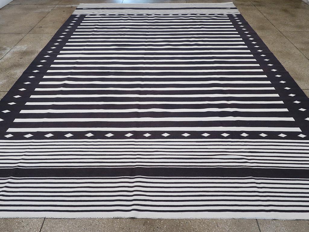This 21st century Indian flatweave Dhurrie rug, measuring 11' 1