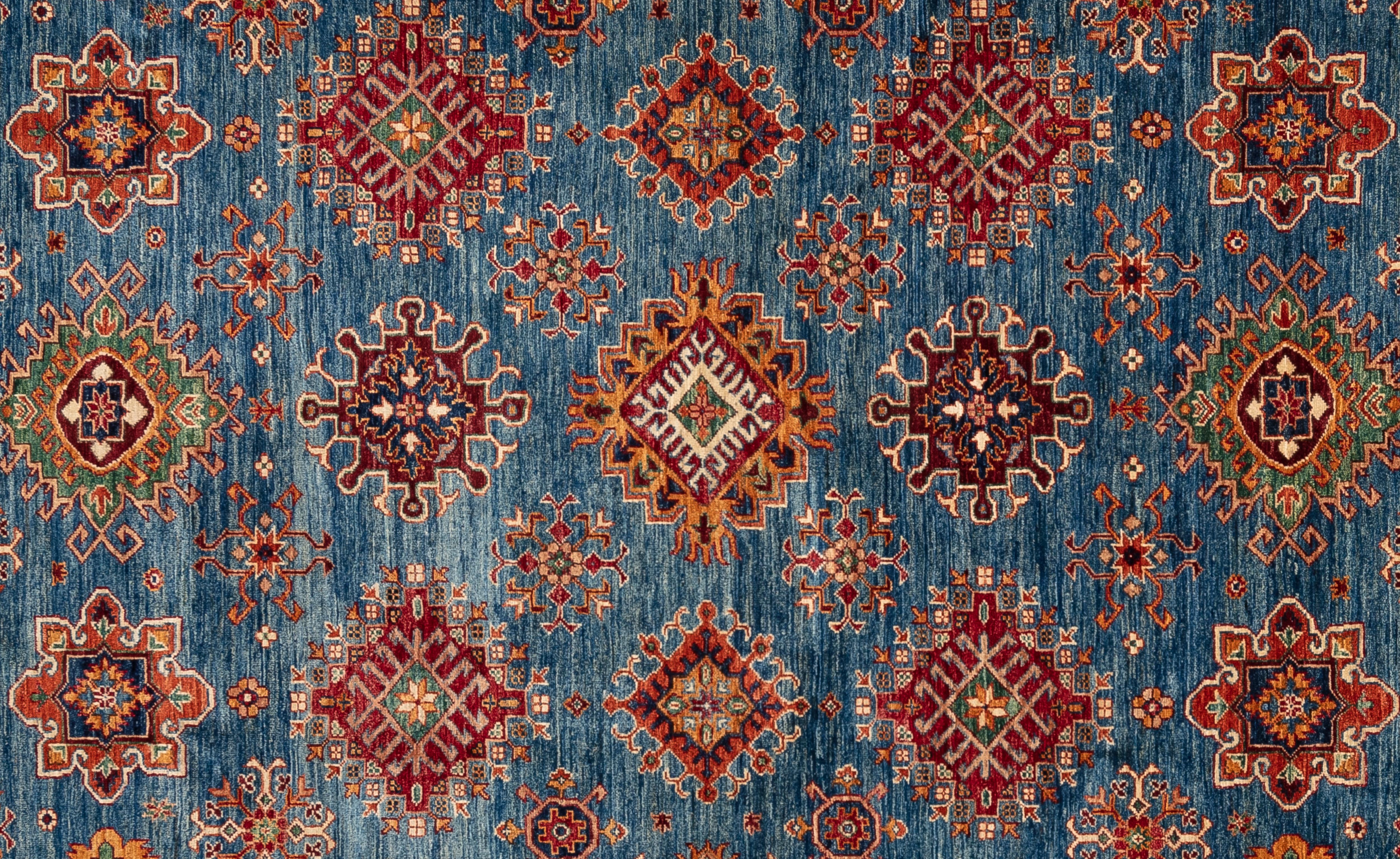 Handgewebt aus 100 % handgesponnener Wolle, in den subtropischen Wäldern Pakistans. Dieser atemberaubende Kazak-Teppich ist von kaukasischen Teppichen inspiriert. Sein allover-Stammesmuster und seine einzigartige Farbgebung machen diesen Teppich zu