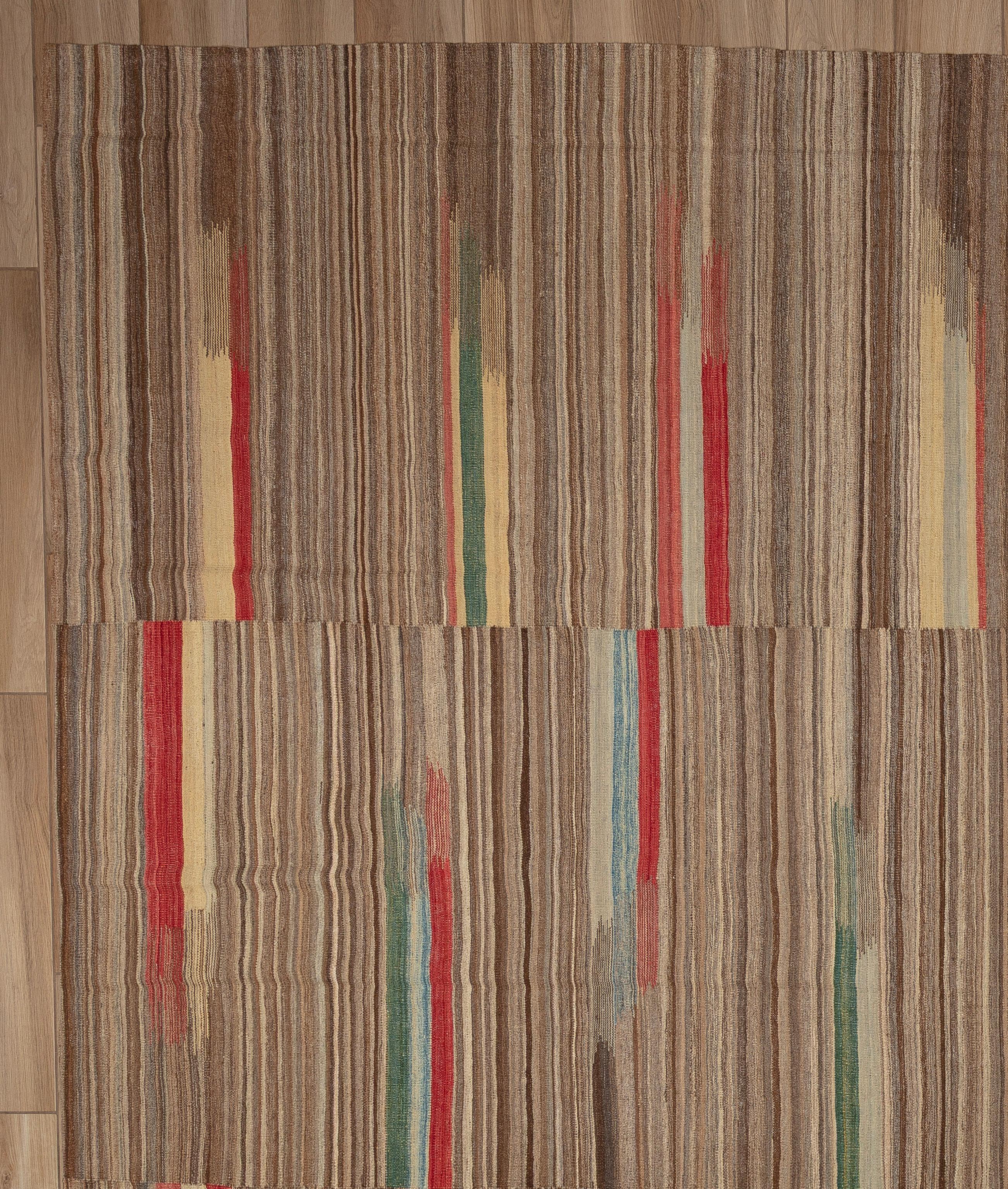 Dieser kühne, flachgewebte und mühelos stilvolle moderne Kelimteppich verleiht einer altehrwürdigen Webtradition eine neue Perspektive. Der aus 100 % Wolle handgefertigte Teppich zeichnet sich durch eine flache, leichte Konstruktion mit der klaren