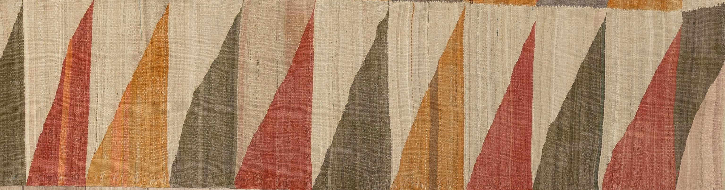 Dieser kühne, flachgewebte und mühelos stilvolle moderne Kelimteppich verleiht einer altehrwürdigen Webtradition eine neue Perspektive. Der aus 100 % Wolle handgefertigte Teppich zeichnet sich durch eine flache, leichte Konstruktion mit der klaren