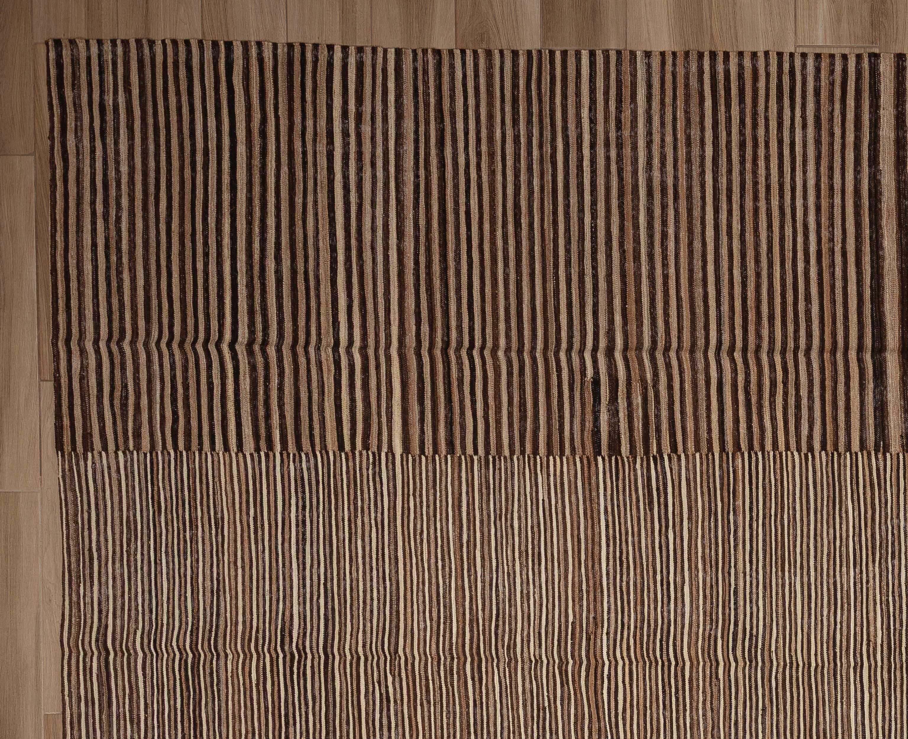 Dieser kühne, flachgewebte und mühelos stilvolle moderne Kelimteppich verleiht einer altehrwürdigen Webtradition eine neue Perspektive. Der aus 100 % Wolle handgefertigte Teppich zeichnet sich durch eine flache, leichte Konstruktion mit der klaren