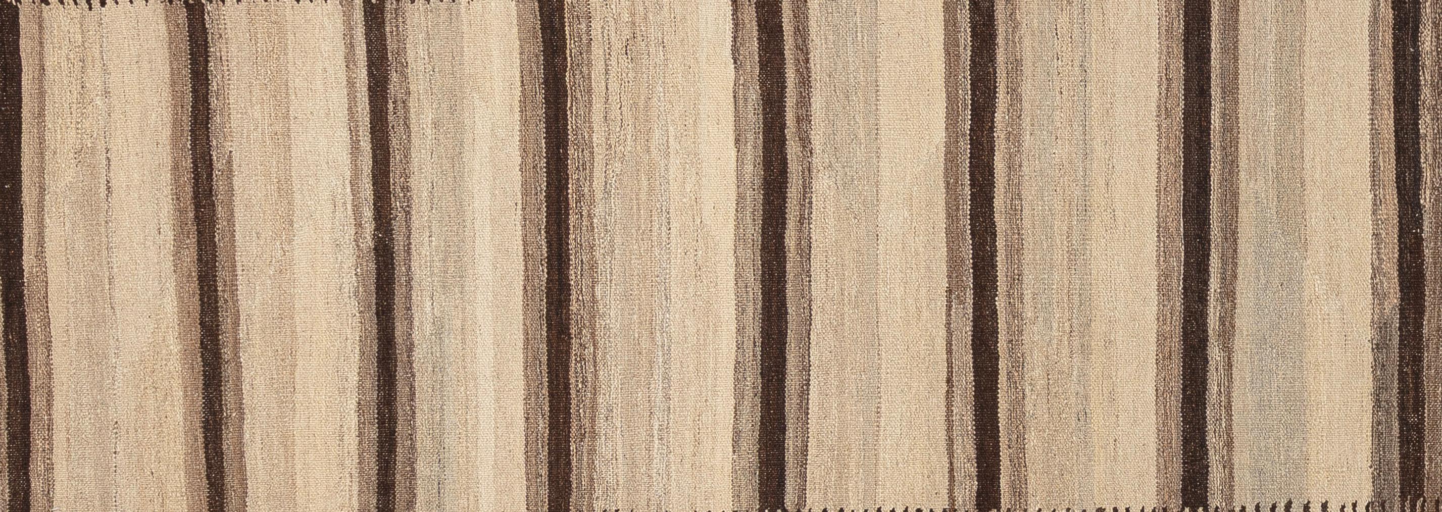 Questo tappeto kilim moderno, audace, tessuto in piano ed elegante, offre una prospettiva nuova a una tradizione di tessitura antica. Realizzato a mano con lana al 100%, il tappeto presenta una struttura leggera e di basso profilo, con la geometria