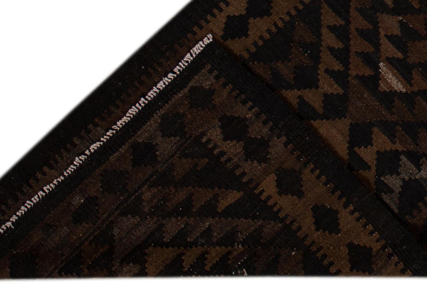Schöner zeitgenössischer Kilim-Teppich aus handgeknüpfter Wolle mit schwarzem Feld und braunen Akzenten in einem geometrischen Multi-Medaillon-Design.
Dieser Teppich misst 2' 9