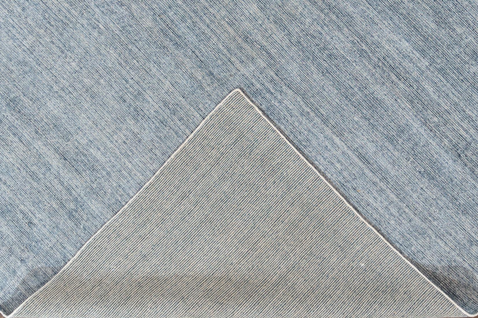A 21st century modern Indian hand-looped/cut Groove rug with an allover slate blue motif. This rug measures 10'0