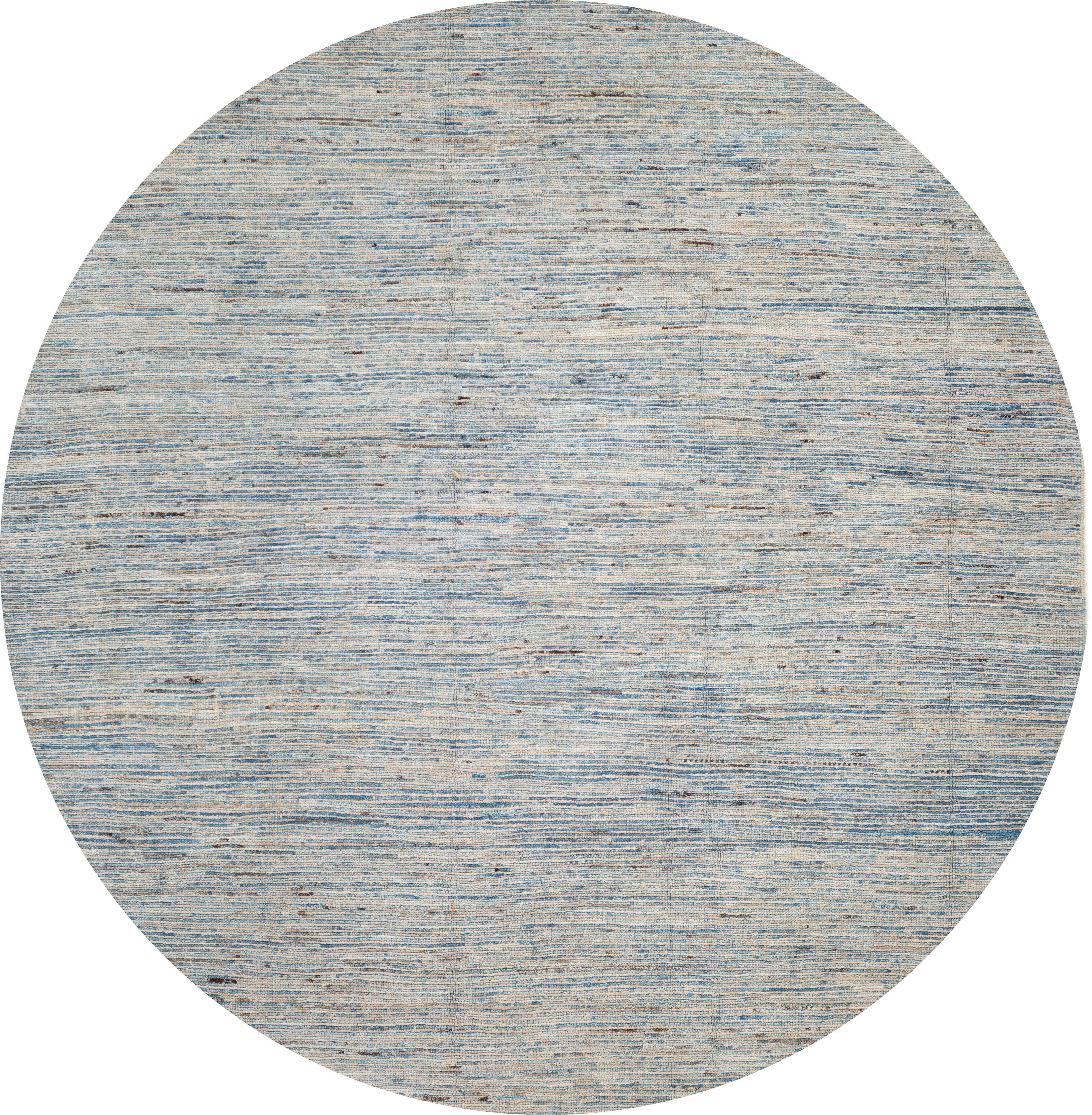 A 21st century Moroccan-style rug, hand knotted from the highest quality wool with a light blue field and finely-striped design. 

This rug measures 7'2