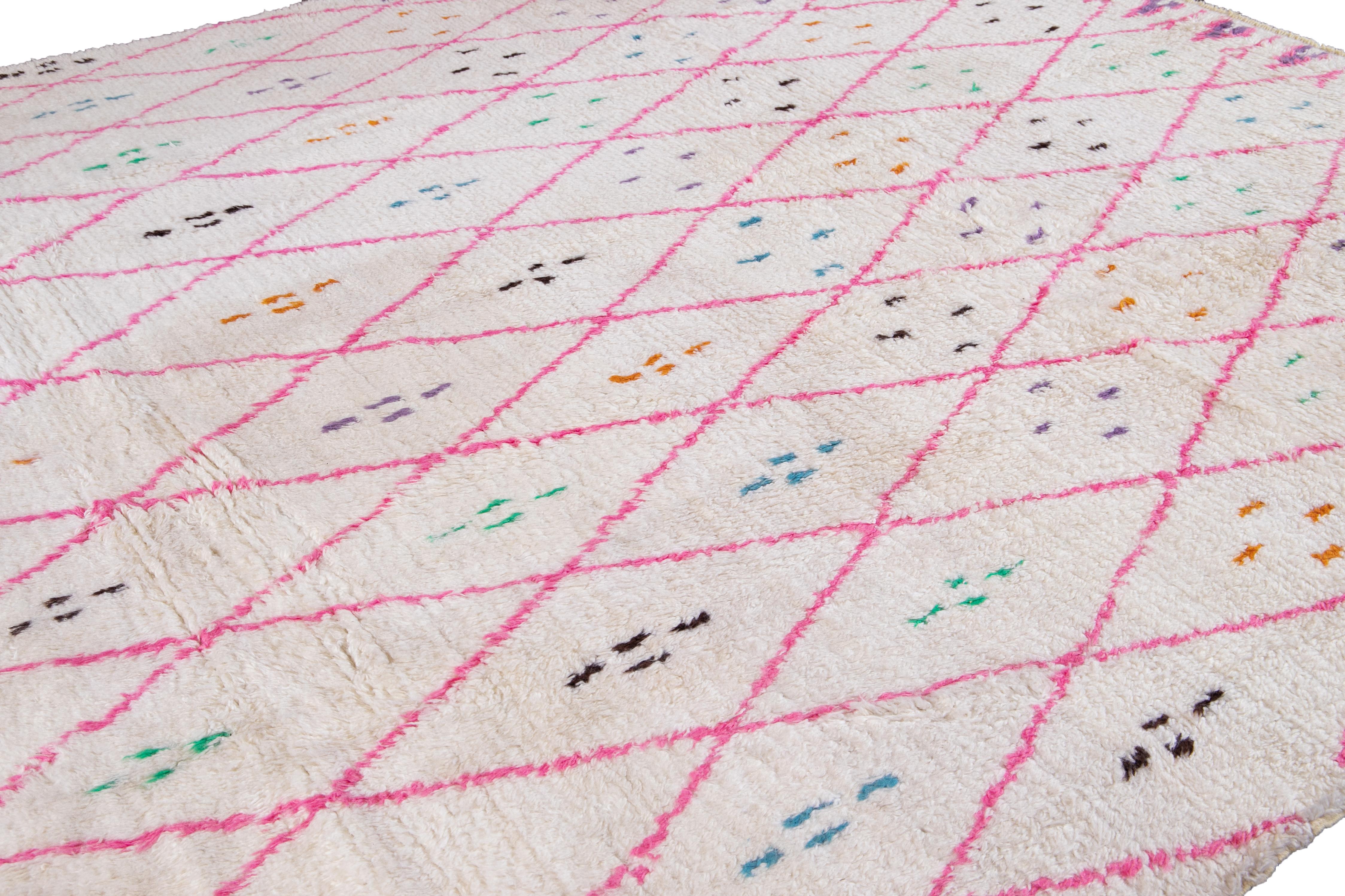 Schöner zeitgenössischer Teppich im marokkanischen Stil, handgeknüpft aus Wolle mit einem elfenbeinfarbenen weißen Feld, leuchtendem Rosa und subtilen mehrfarbigen Akzenten in einem herrlichen, böhmisch inspirierten Design.
Dieser Teppich misst: