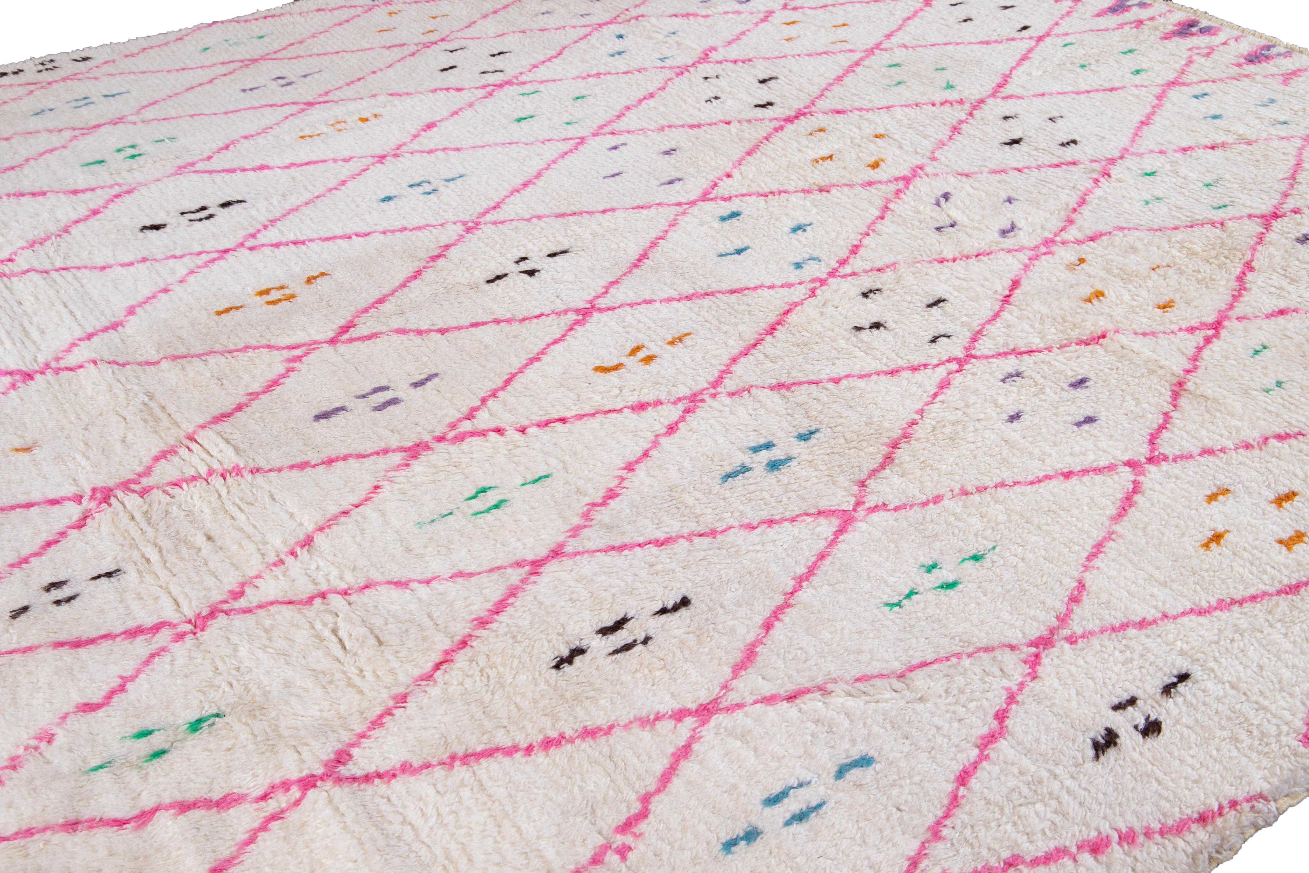 Beautiful contemporary Moroccan style rug, hand knotted wool with an ivory white field, bright pink and subtle multicolor accents in a gorgeous Bohemian-inspired design.
This rug measures: 10'4