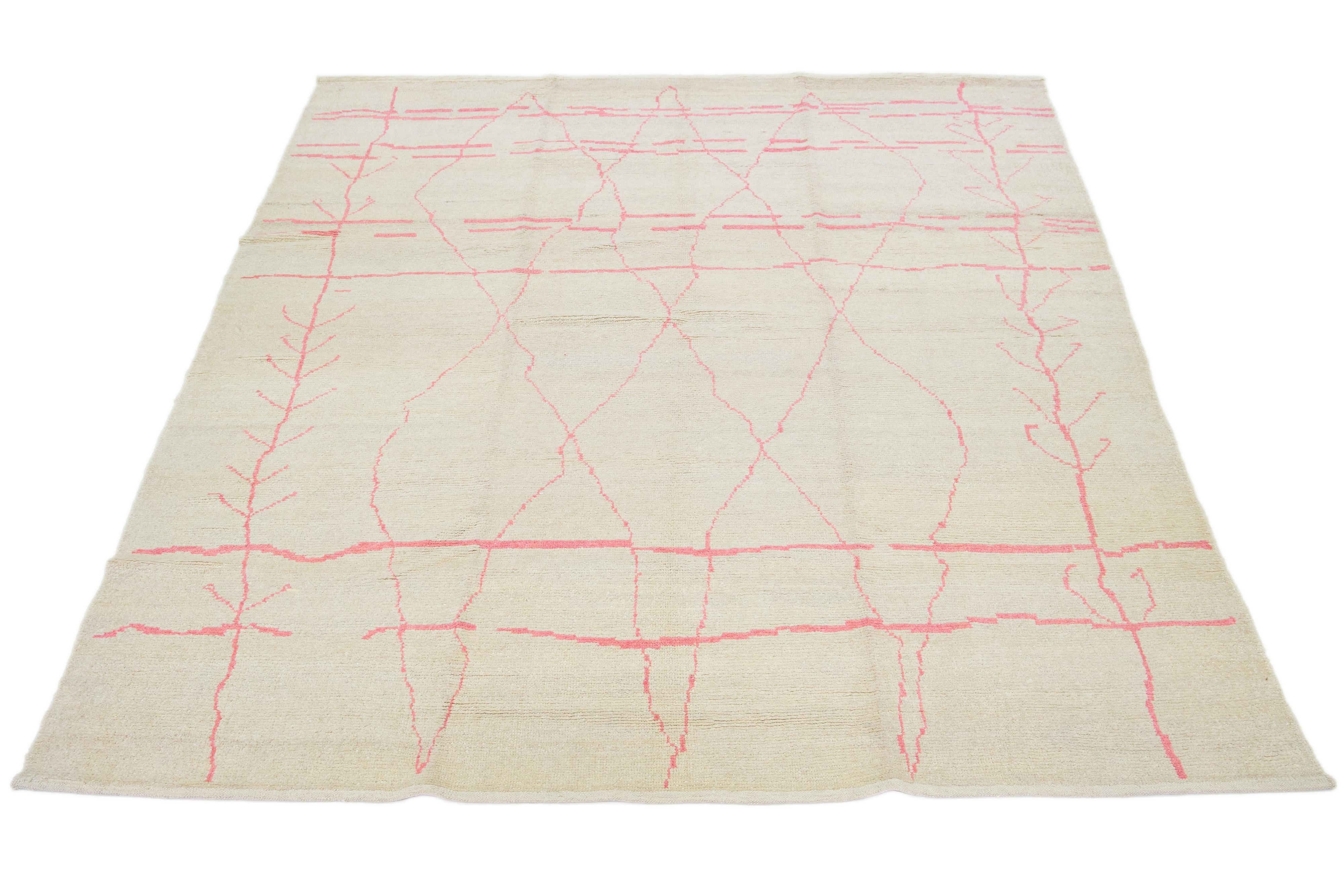 Beautiful Moroccan-style rug, hand knotted wool with an ivory field, pink accents in a gorgeous all-over tribal design.

This rug measures 9' x 12' 2