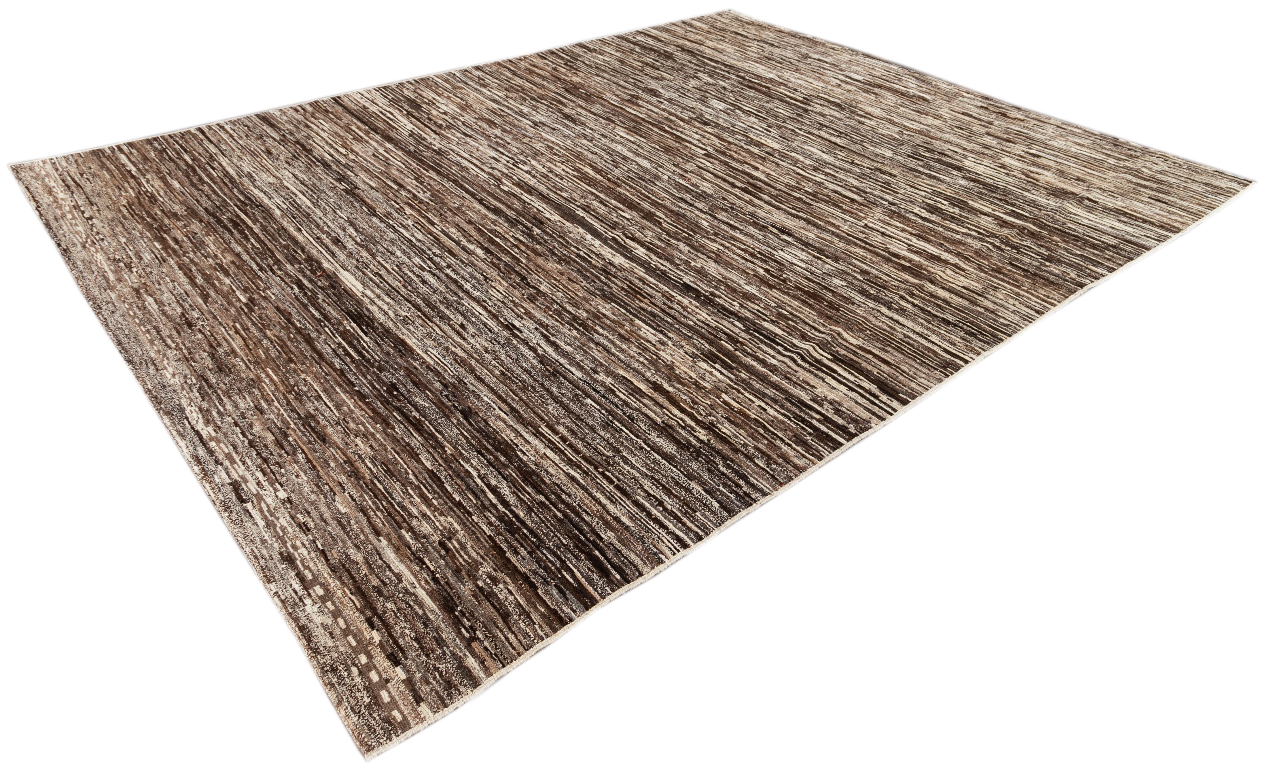This is a modern rug designed in Moroccan style. It is manually knotted from premium-quality wool. The rug features a brown color field complemented by a distinct, solid motif.

 This rug measures 9' 2