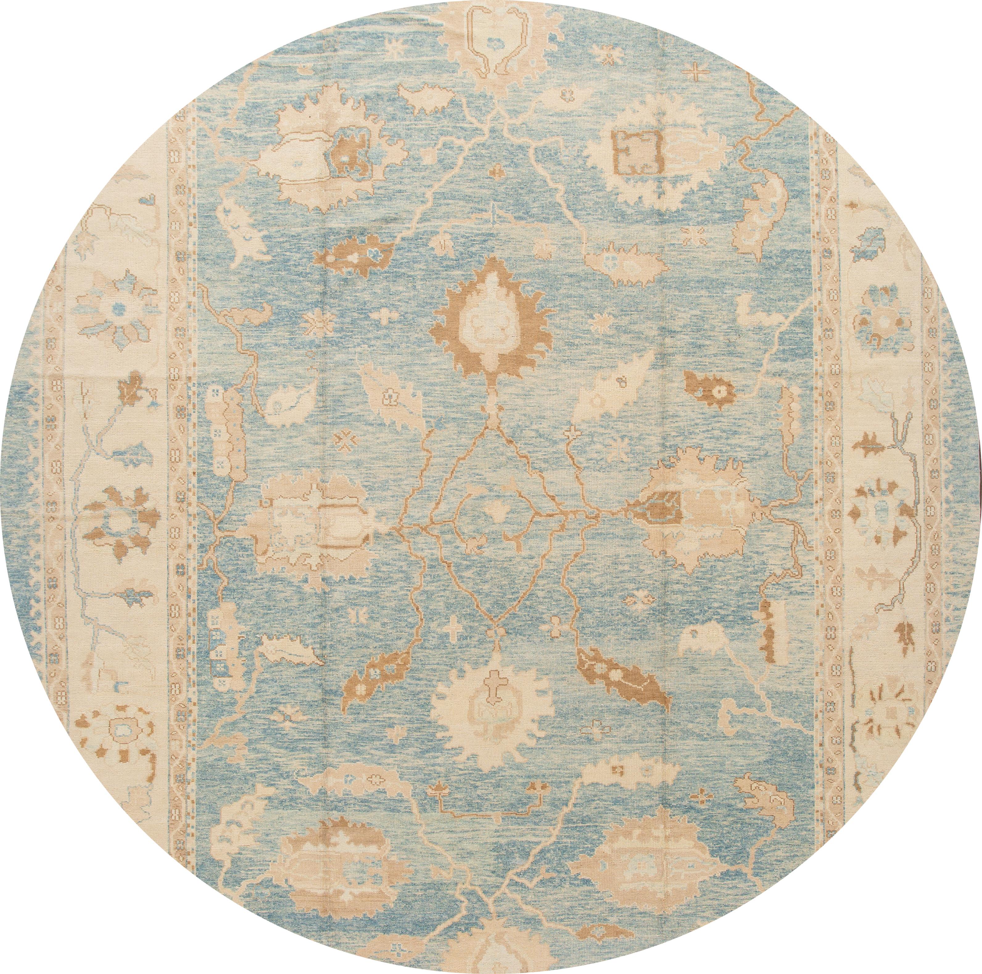 Beautiful contemporary oversize Turkish Oushak rug, hand knotted wool with a blue field, cream frame, tan and brown accents in an allover design.
This rug measures 12' 8