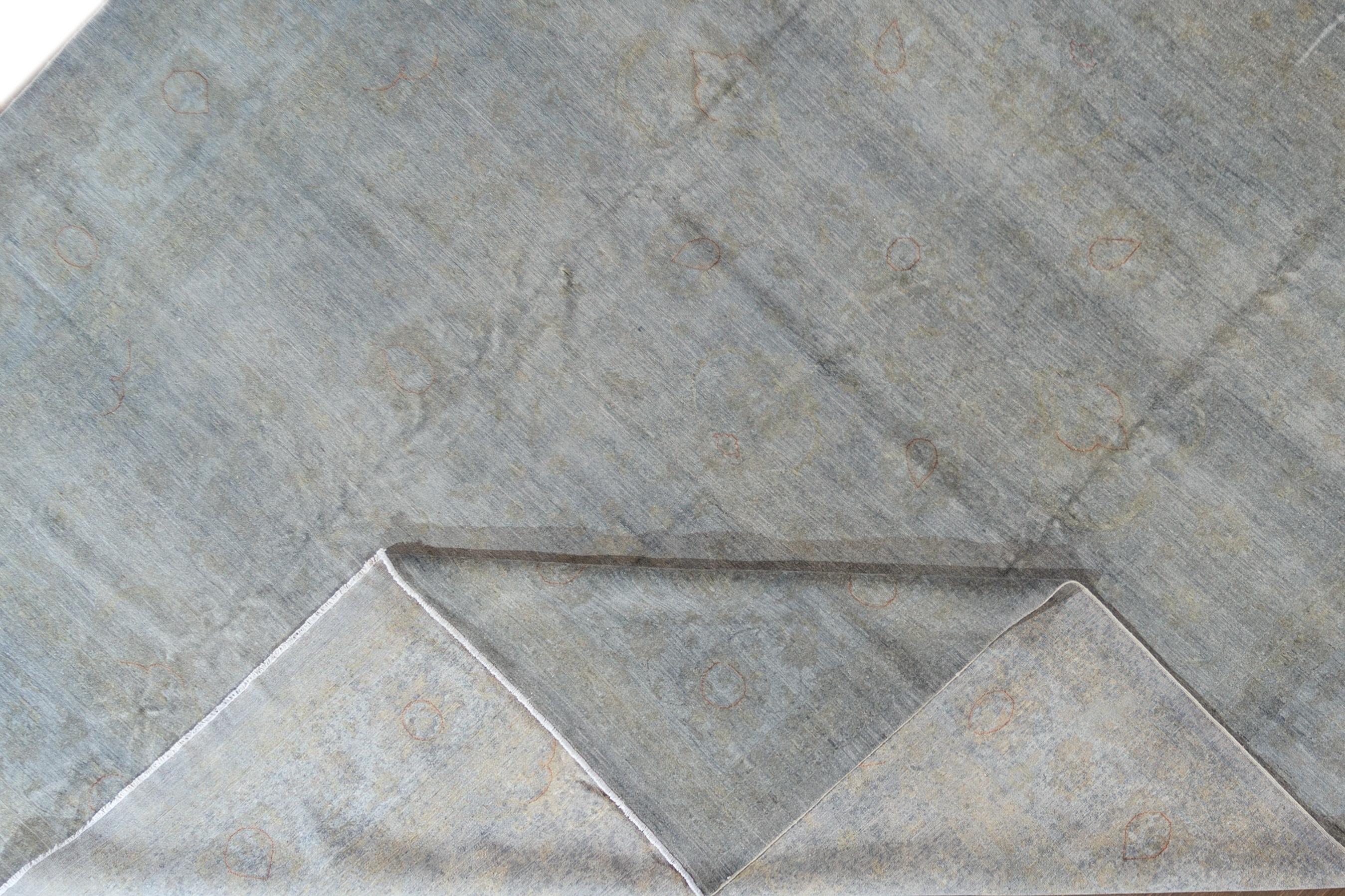 A 21st century modern hand knotted wool overdyed rug with a grey all-over design. This rug measures 13'7