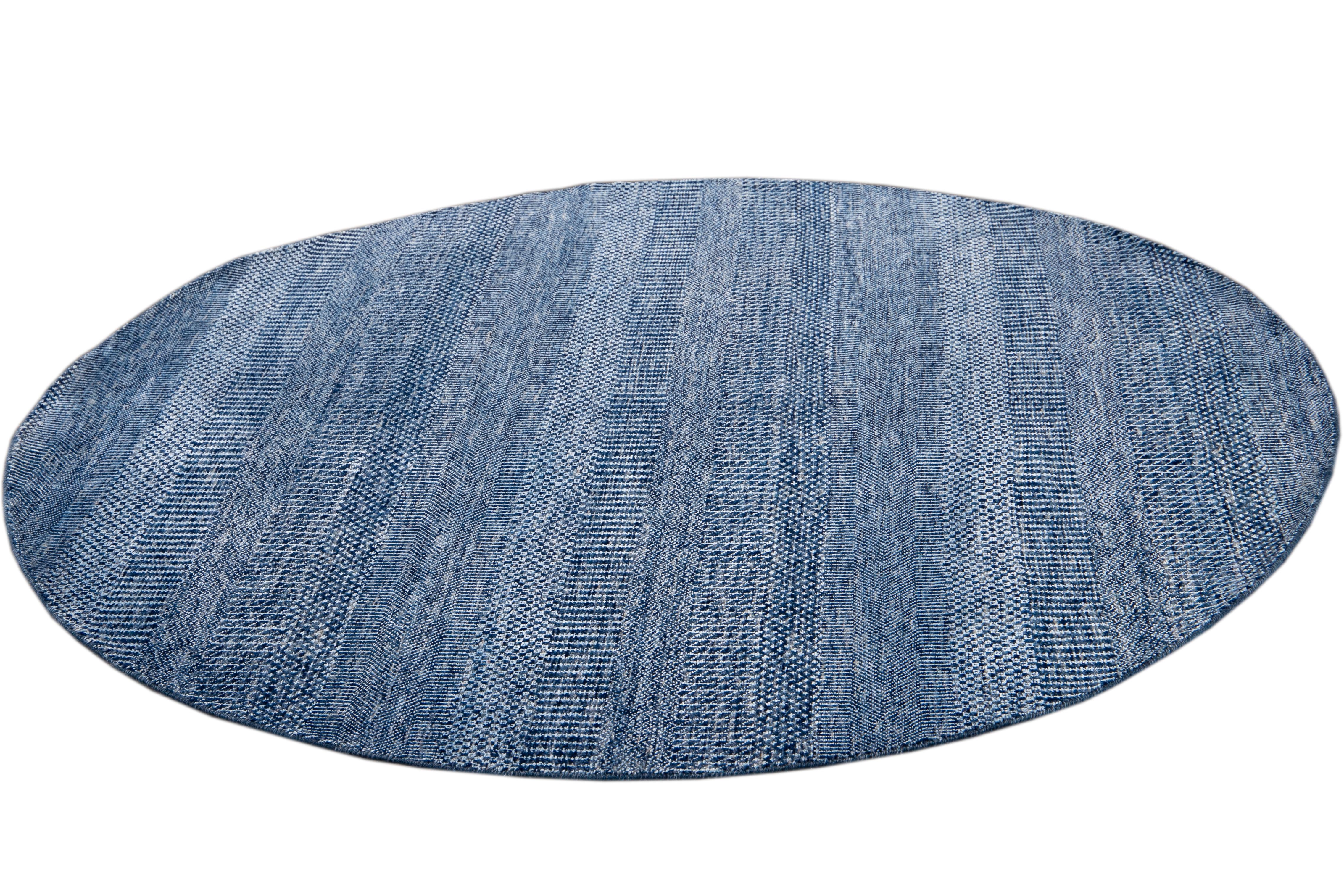 Beautiful contemporary Savannah round rug, hand knotted wool with a bright blue field in an all-over striped design.
This rug has a diameter of 6' 0