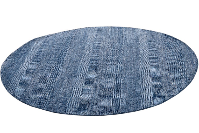 Beautiful contemporary Savannah round rug, hand knotted wool with a bright blue field in an all-over striped design.
This rug has a diameter of 6' 0