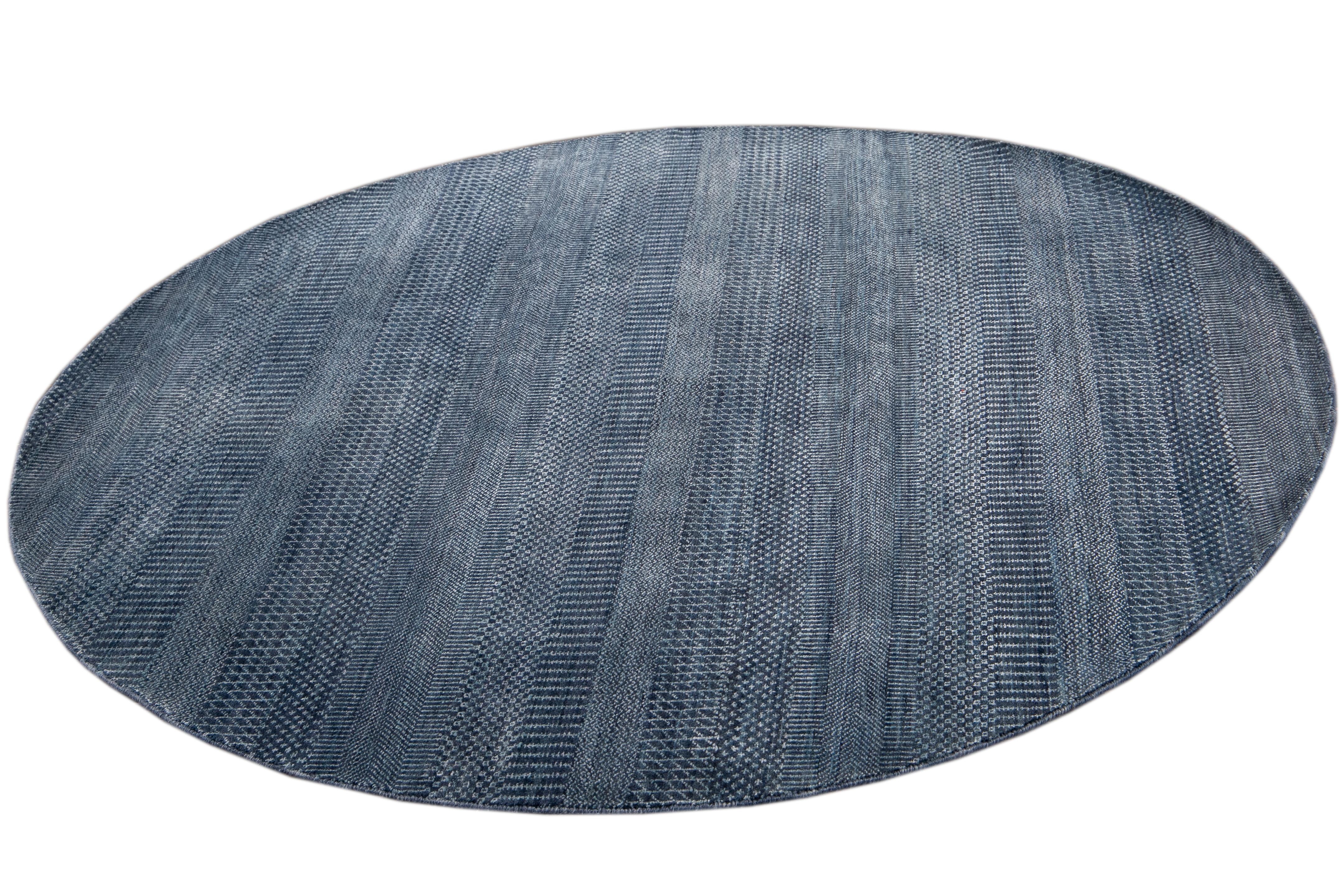Beautiful contemporary Savannah round rug, hand knotted wool with a dark blue field in an all-over striped design.
This rug has a diameter of 5' 10