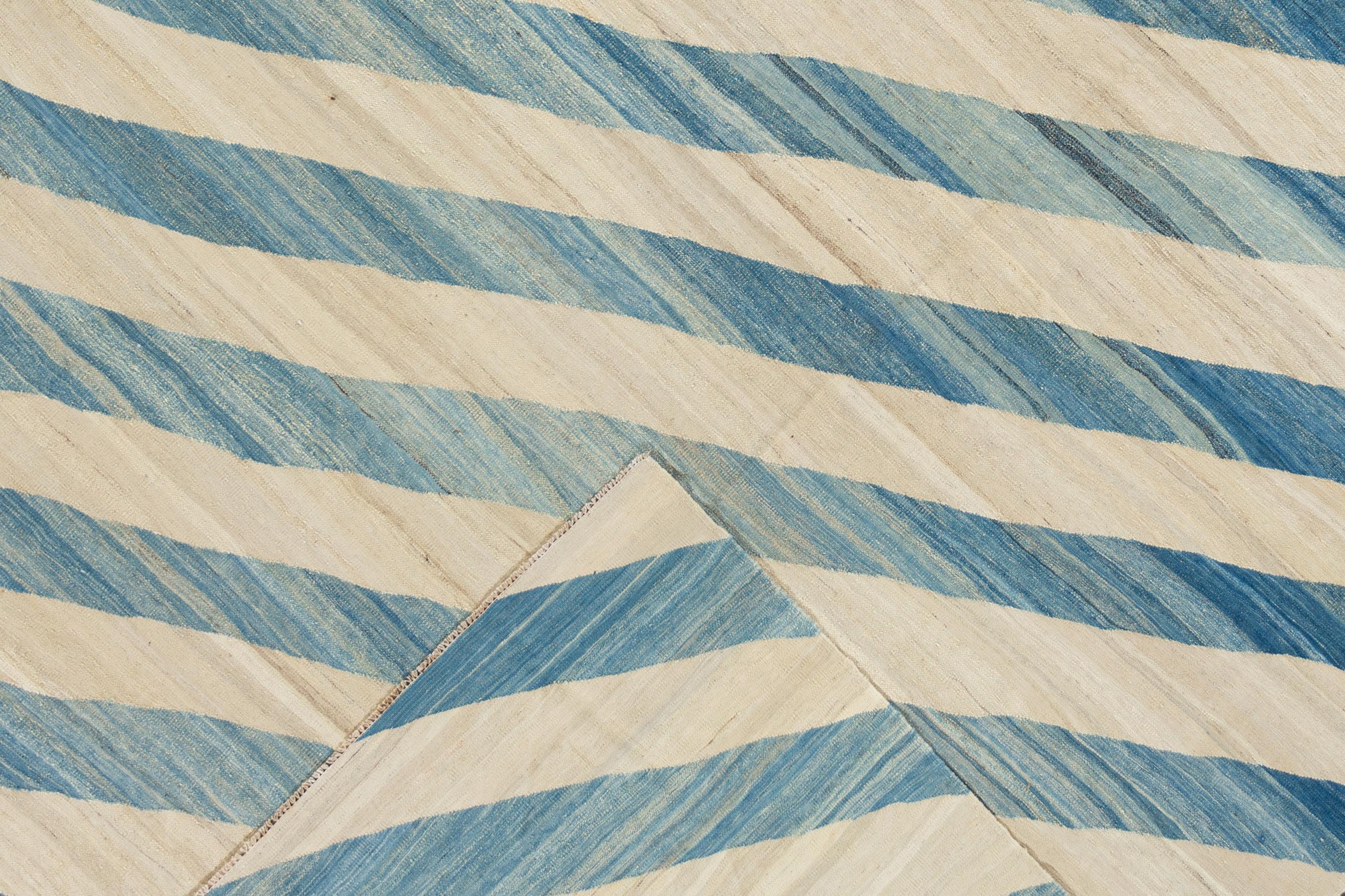 Beautiful hand knotted modern kilim wool rug. This rug has a blue field with ivory stripes. 


This rug measures: 8'11