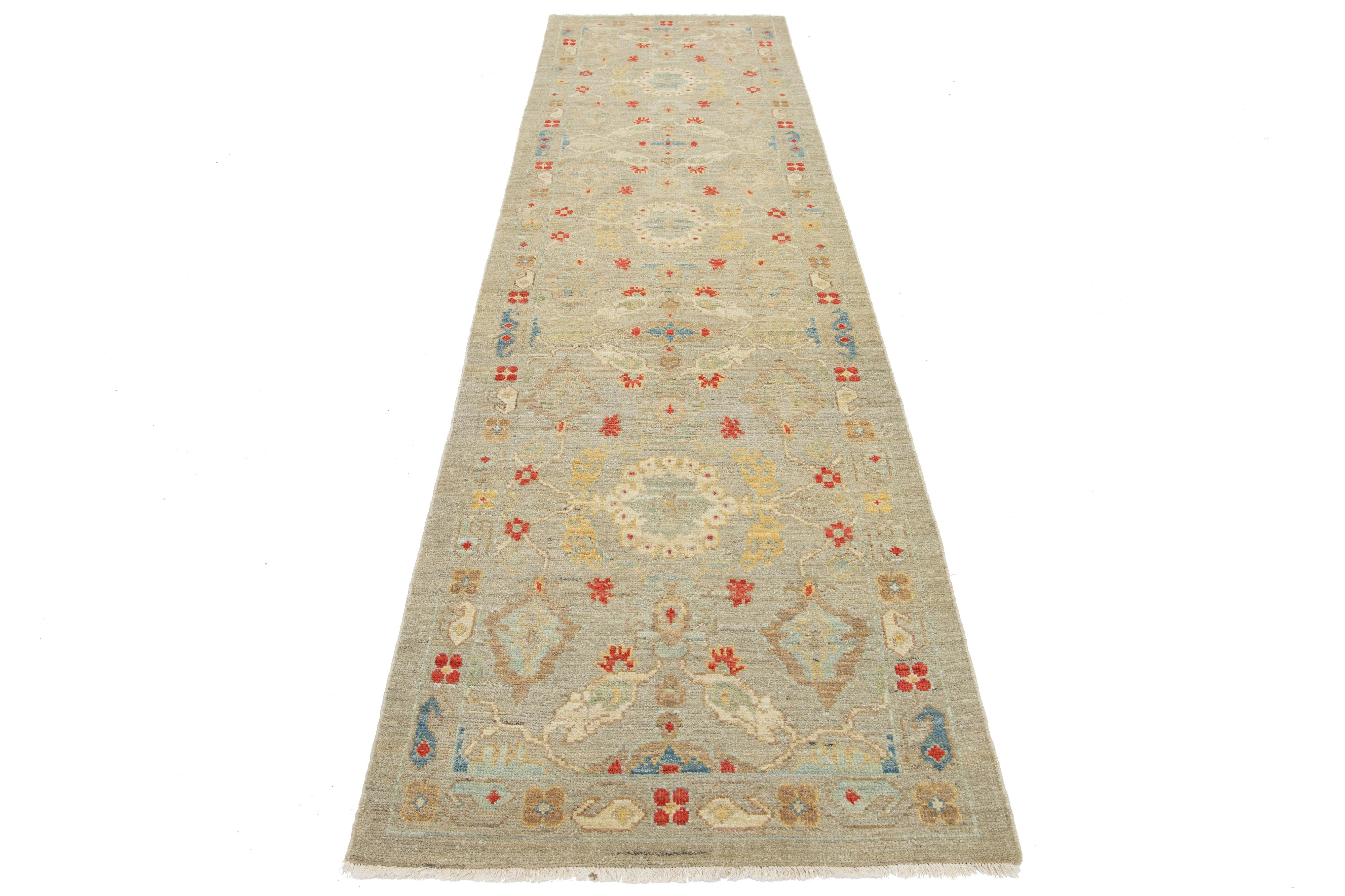 Il design presenta un bellissimo tappeto runner contemporaneo Sultanabad Rugs, annodato a mano in lana e caratterizzato da un campo grigio chiaro e beige con accenti rossi e blu intensi. Questa somiglianza è dovuta alla magnifica natura grafica dei