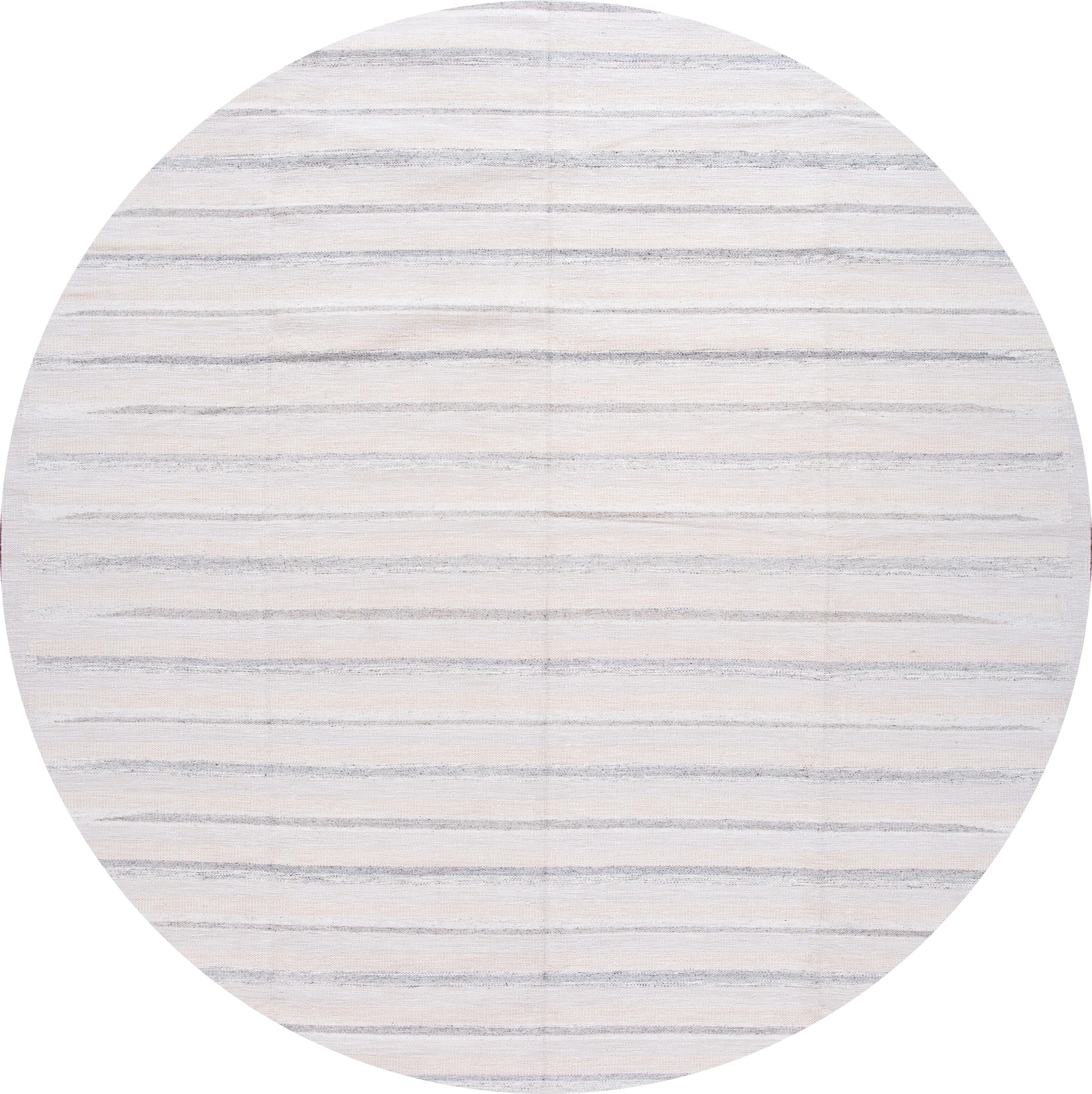 Beautiful 21st century modern Swedish hand knotted wool rug with an ivory field, beige, and gray accents in an all-over stripe design

This rug measures: 12'1