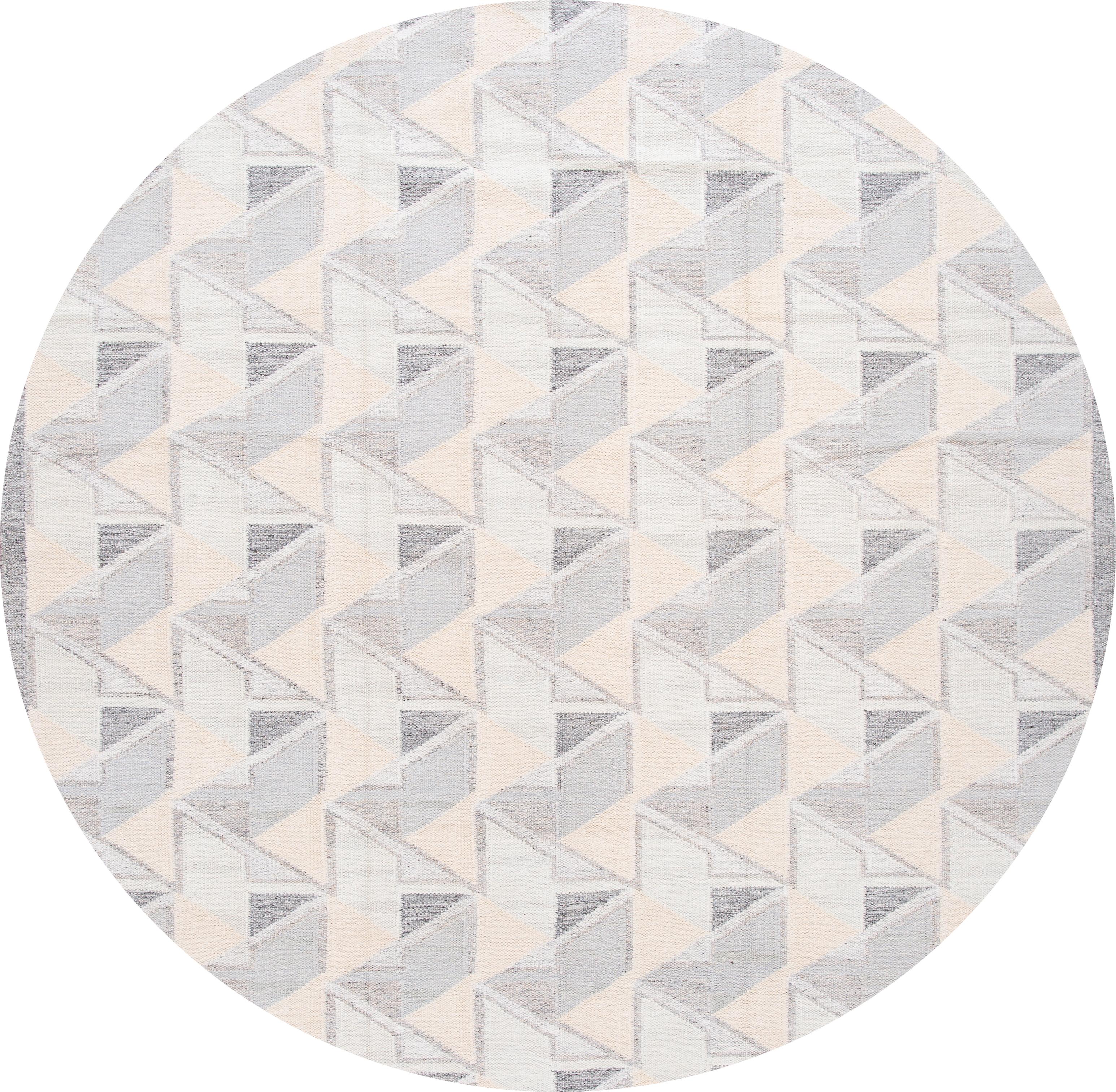 Beautiful 21st century modern Swedish hand knotted wool rug with an ivory field, beige, and gray accents in an all-over geometric design

This rug measures: 10' x 13' 10