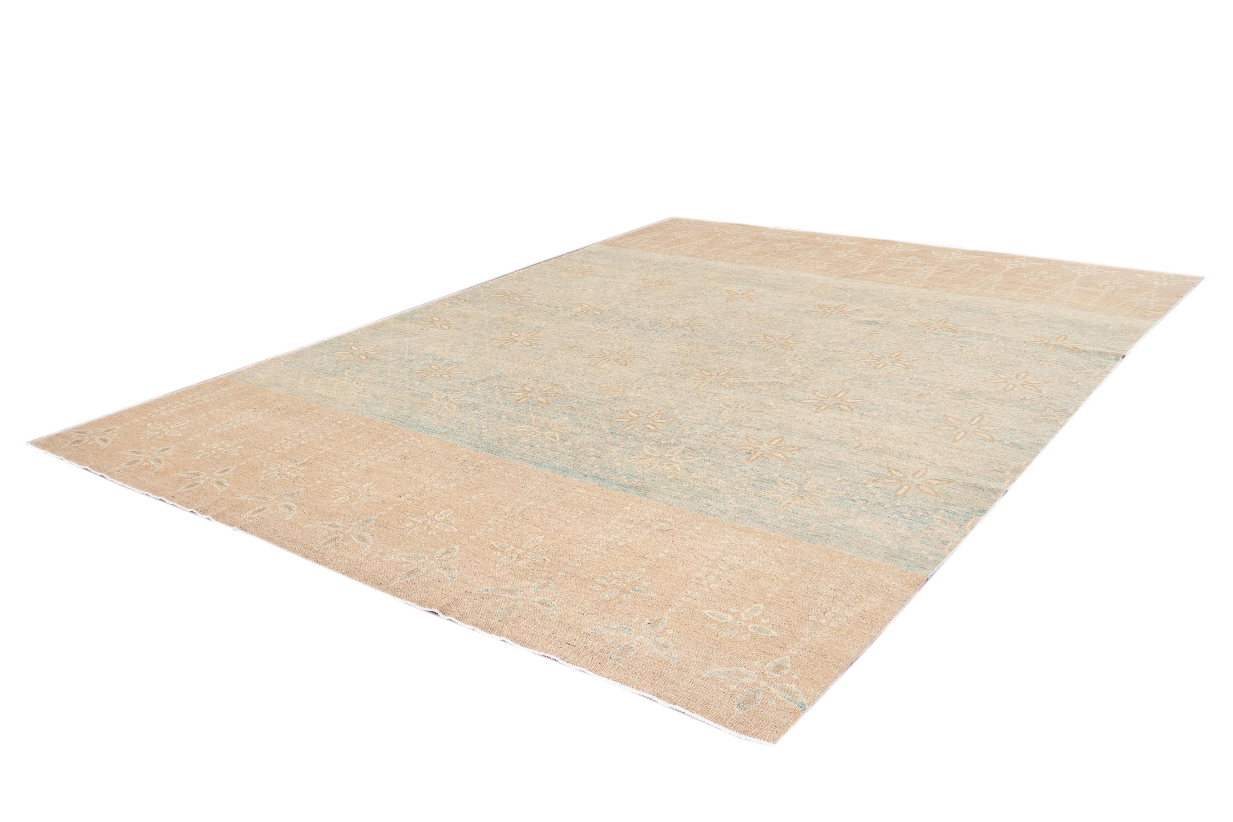 Beautiful contemporary wool rug with a light blue field and pale orange border and ivory accents with an all-over floral design. 

This rug measures 9' 6