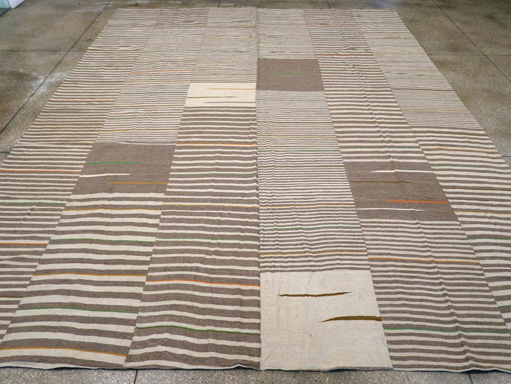 Esta alfombra turca Flatweave Kilim del siglo XXI, que mide 3,8 m x 4,8 m, presenta una versión contemporánea de las técnicas de tejido tradicionales, que combina la sencillez con la expresión artística. El diseño consiste en paneles verticales,