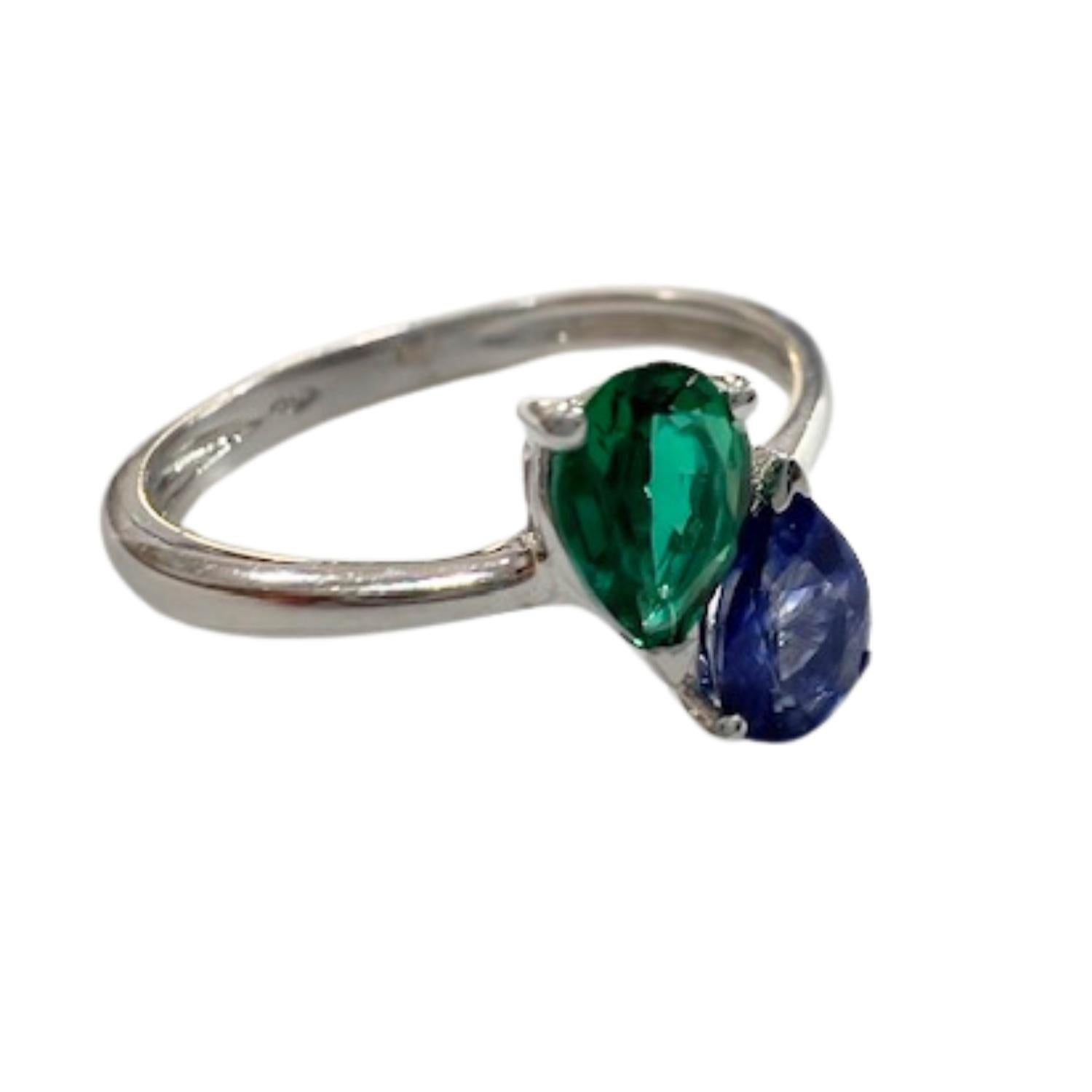 A sleek, contemporary design featuring a pear-shaped sapphire and emerald set in 18K gold. A refined and vibrant piece for modern elegance.

**IN STOCK**

Key Features:

Metal: 18K Gold
Main Stones:
Sapphire (0.40 ct, Ceylon origin, pear
