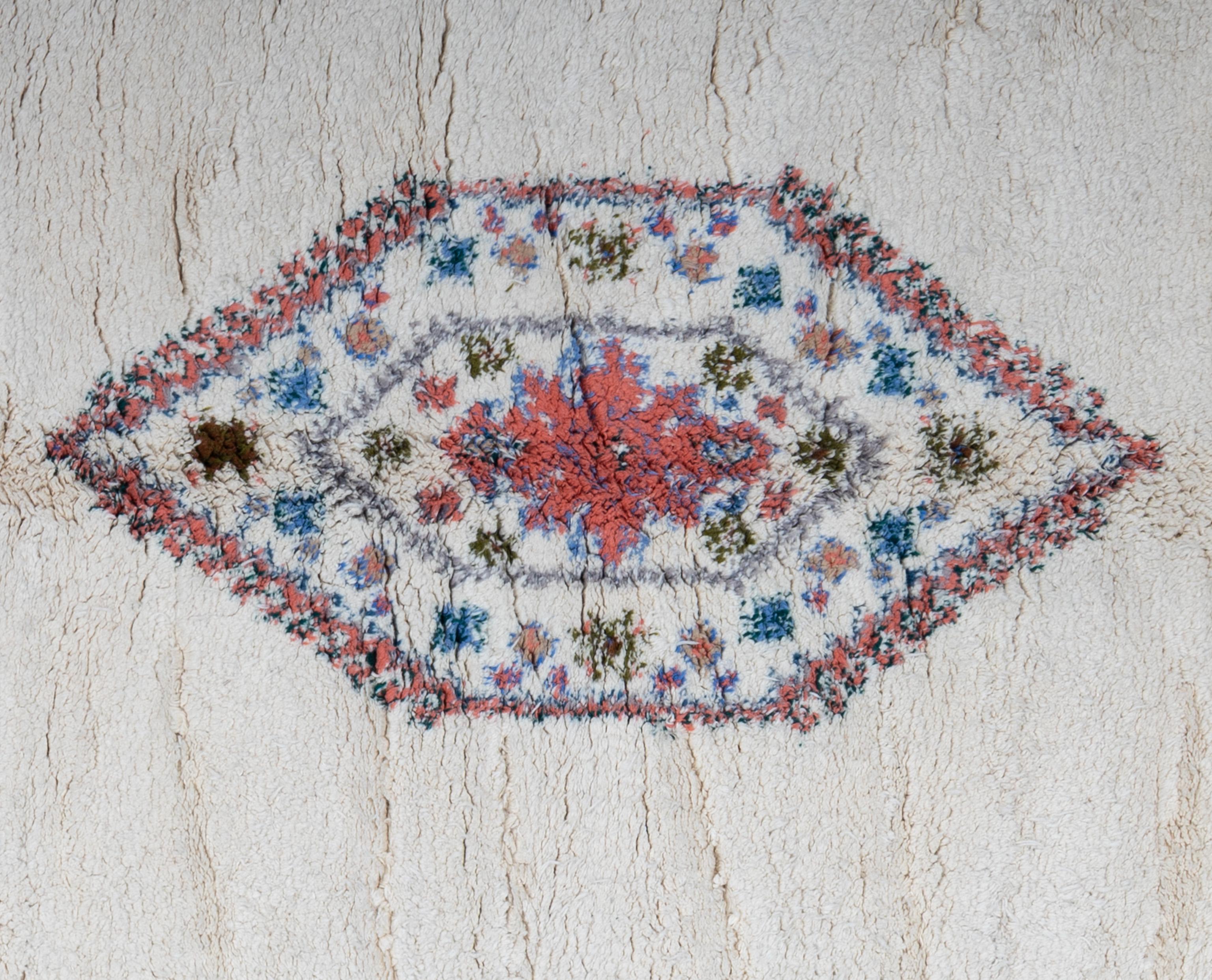 Elevate your home décor with this beautiful Moroccan rug, a true masterpiece of artisan craftsmanship. This rug features a high pile, geometric patterns and captivating tones, and adds a touch of exotic elegance to any room. Handwoven with care and