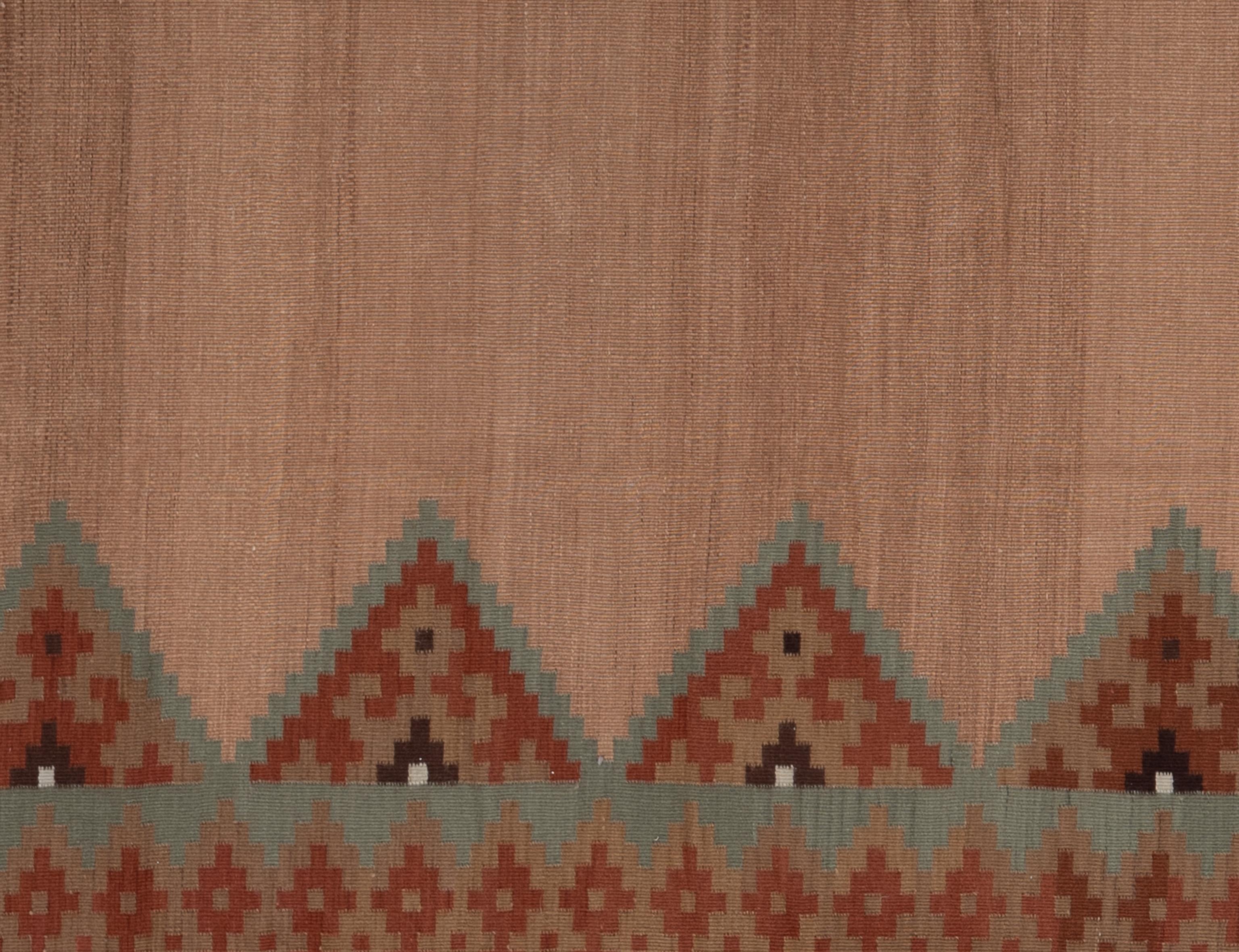 This handwoven Zapotec rug from Mexico, features a bold tribal design with rustic red, mauve tones and accented by deep brown colors. Crafted from high-quality wool, the rug showcases classic Zapotec patterns including diamonds, crosses, and angular