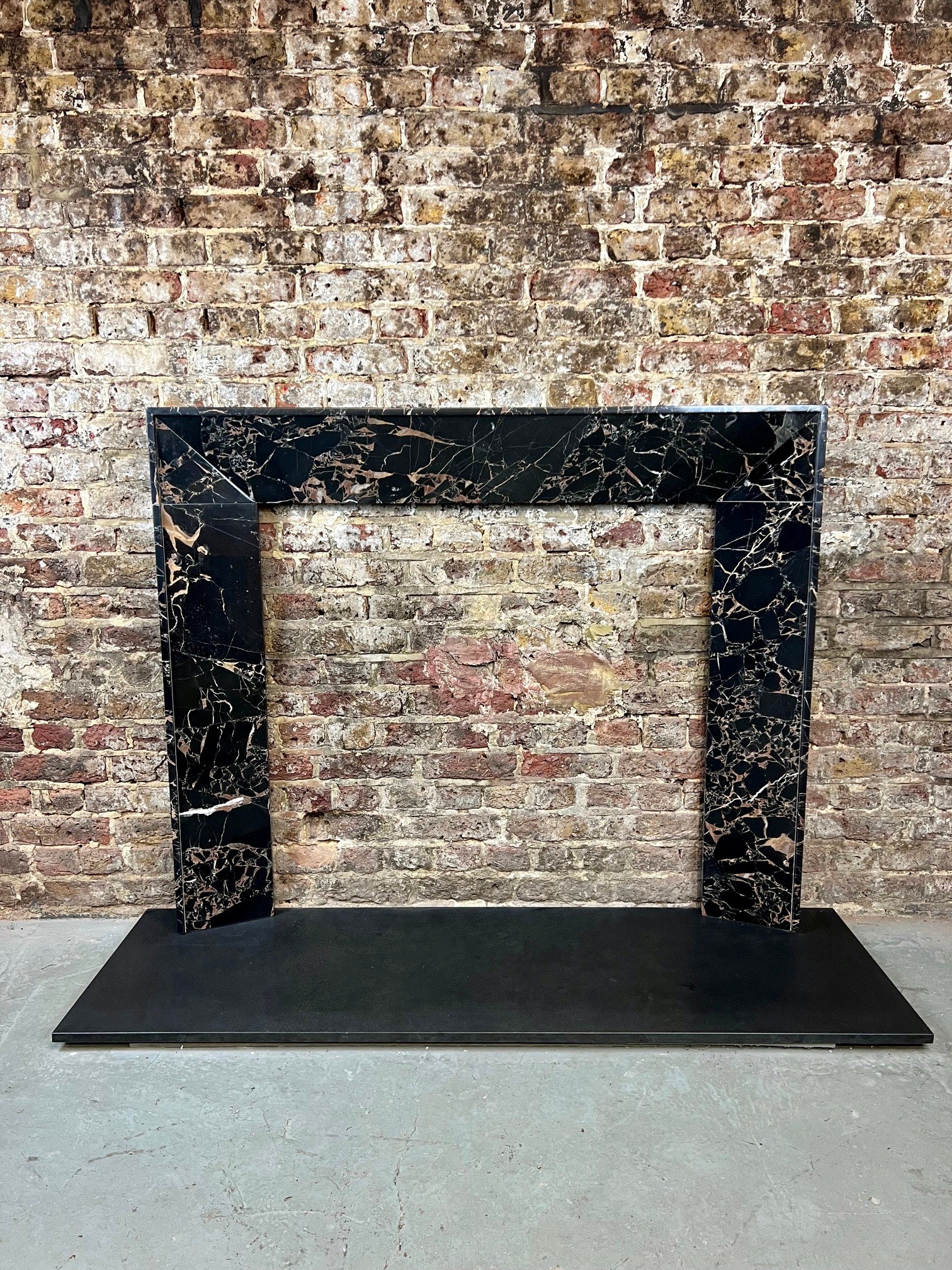21e siècle Cheminée en marbre Nero Portoro .
Ce design contemporain de manteau de cheminée est en fait basé sur un modèle traditionnel. 
Design/One. Il a été sculpté à la main dans du marbre Nero Portoro sélectionné, 
Qui a une toile noire profonde