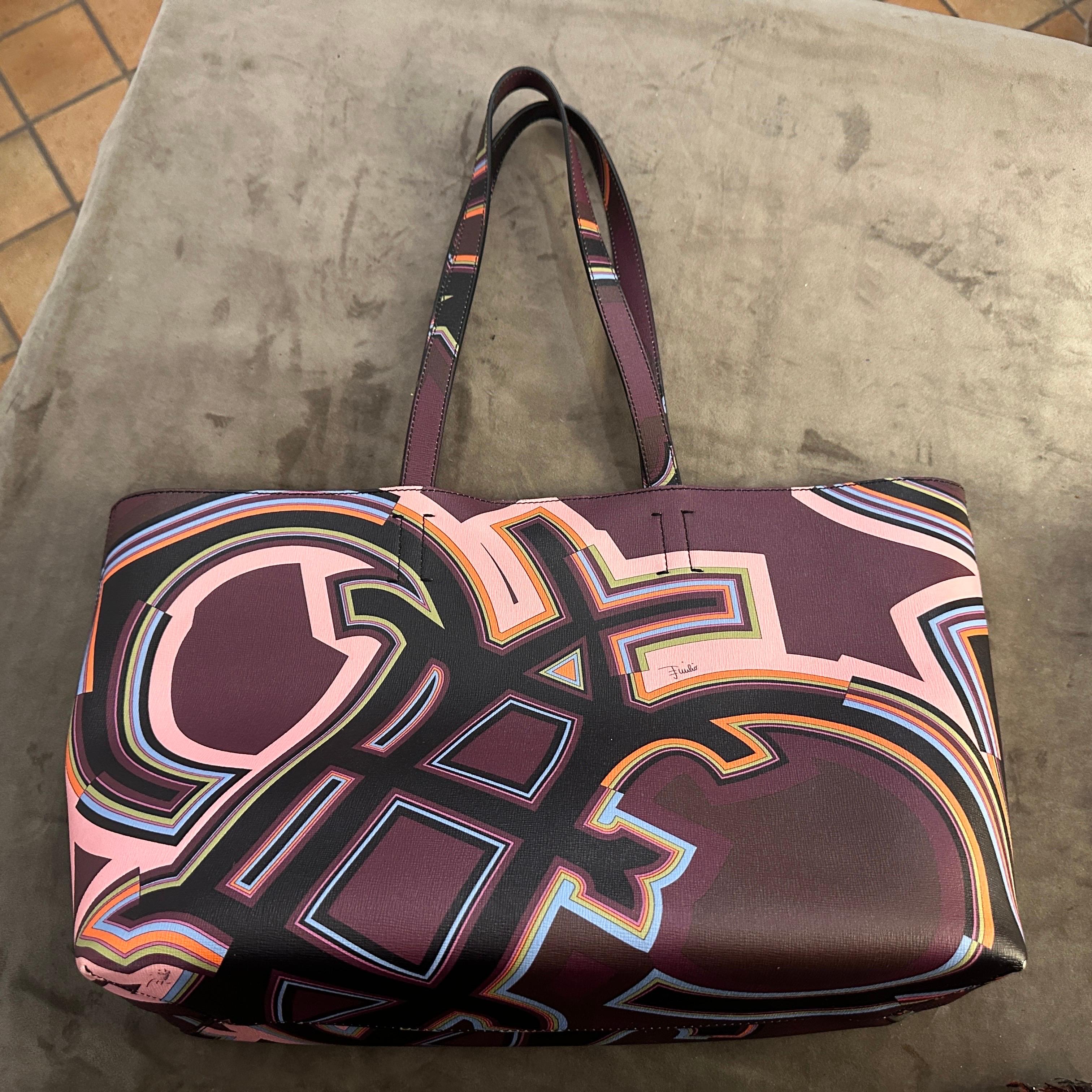 This never-worn Pucci tote exudes an air of  unparalleled luxury and playful sophistication. It's a statement piece, a conversation starter, a testament to the brand's enduring legacy.  It comes with its original dust bag, authenticity cards, and