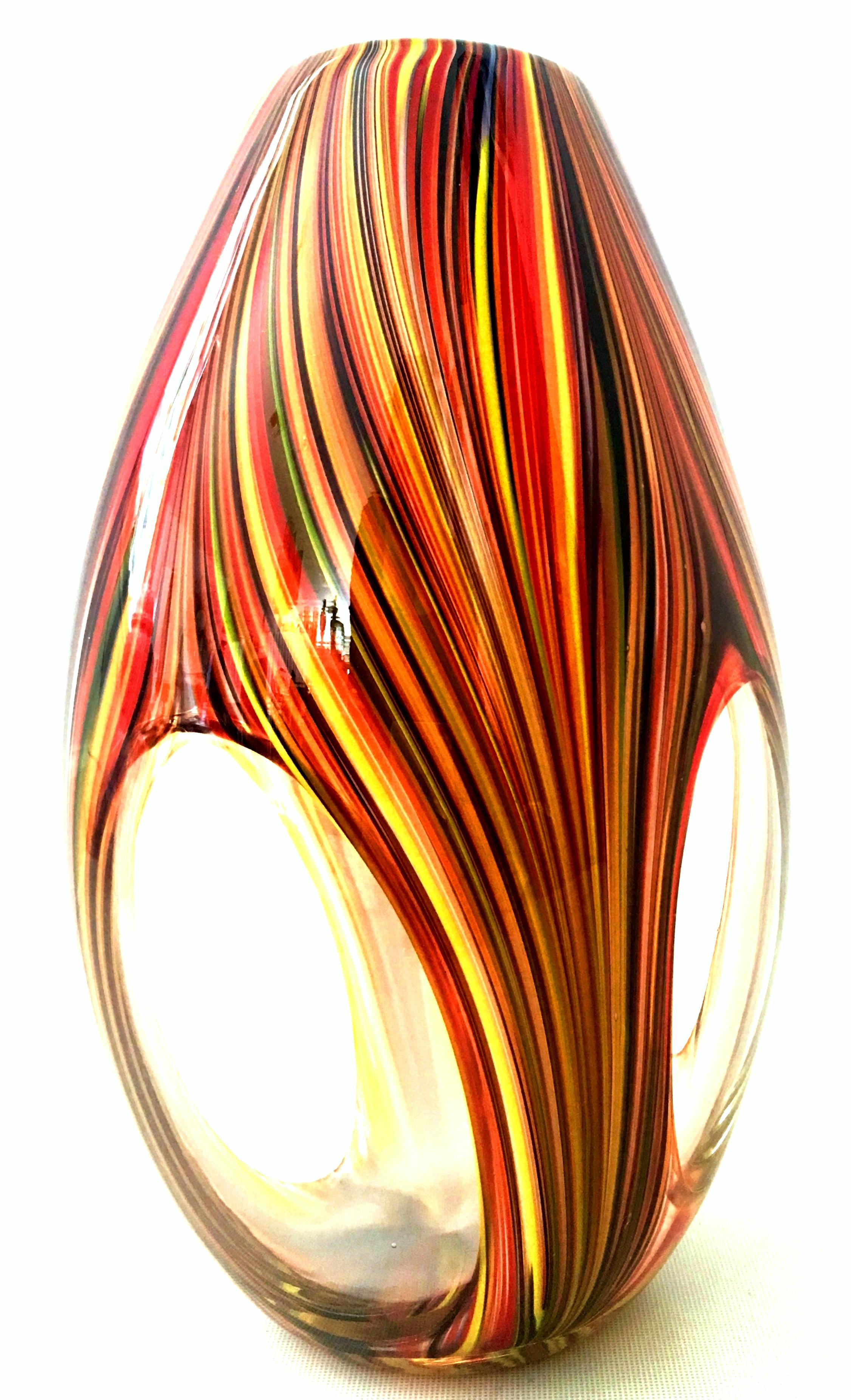 21st century and new Missoni modern optical striped blown glass vase. This new and never used ultra modern optical striped design blown glass vase by Missoni features a color palette with shades of orange, yellow, periwinkle, red and brown. This