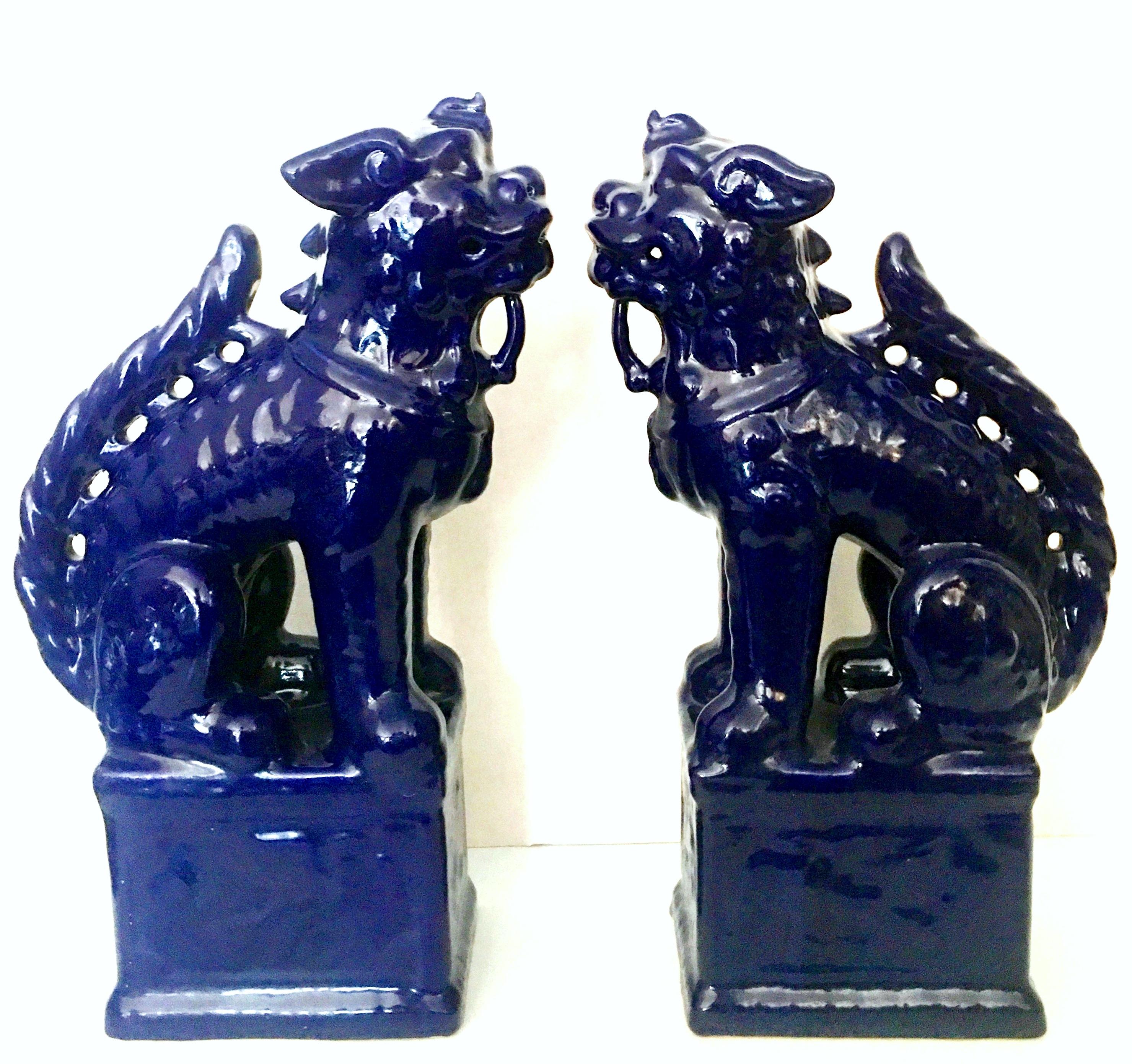 21st century pair of Chinese foo lion sculptures. These tall vibrant cobalt foo dog sculptures are made of glazed ceramic and are a high gloss finish.
New-floor sample, used for retail display only.