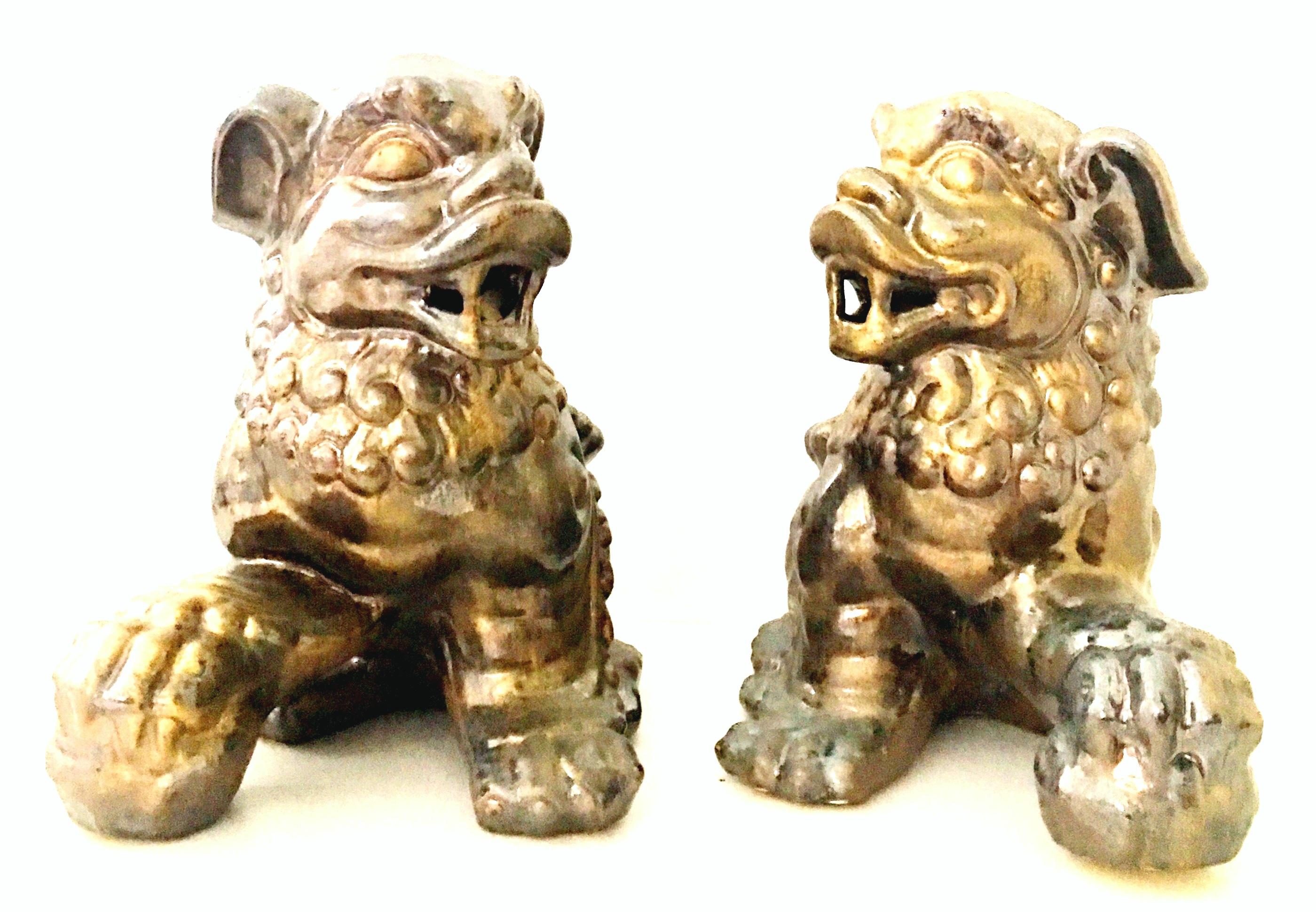 21st century contemporary pair of gold ceramic glaze foo dog sculptures. This large pair of foo dogs, has a metallic burnished gold gloss finish.